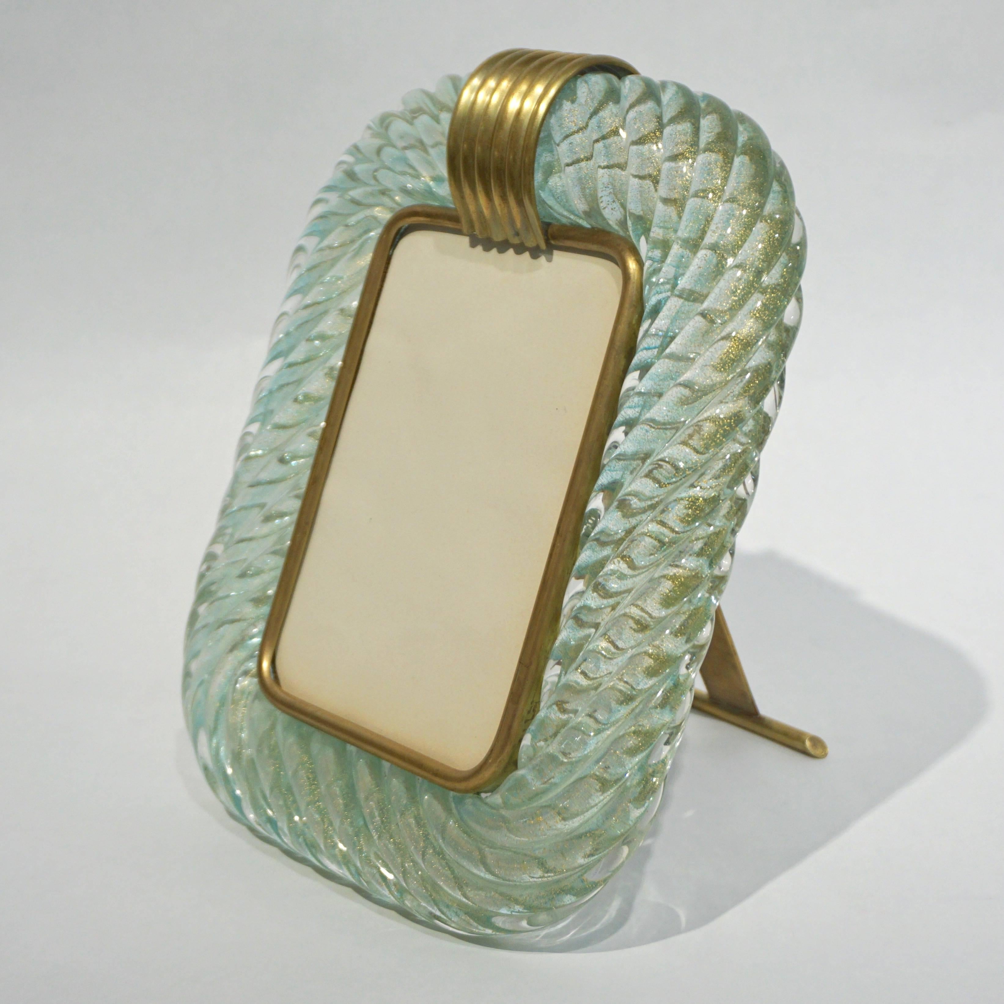 1970s vintage Murano glass picture frame worked with organic “torchon”: handcrafted twisted blown Murano glass, in an unusual green cyan / teal tint, preciously decorated with pure gold in the glass that confers a glow throughout, enhanced by the