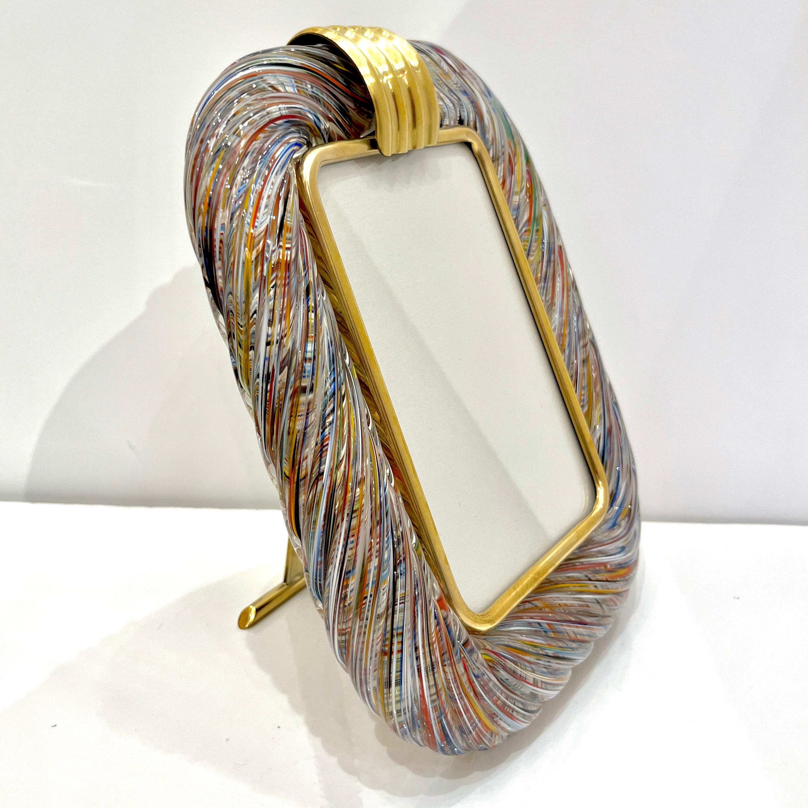 21st century modern sophisticated and elegant contemporary picture frame in thick blown Murano glass: the crystal clear glass frame worked with “torchon” technique, handcrafted twisted blown Murano glass that amplifies the reflections, is