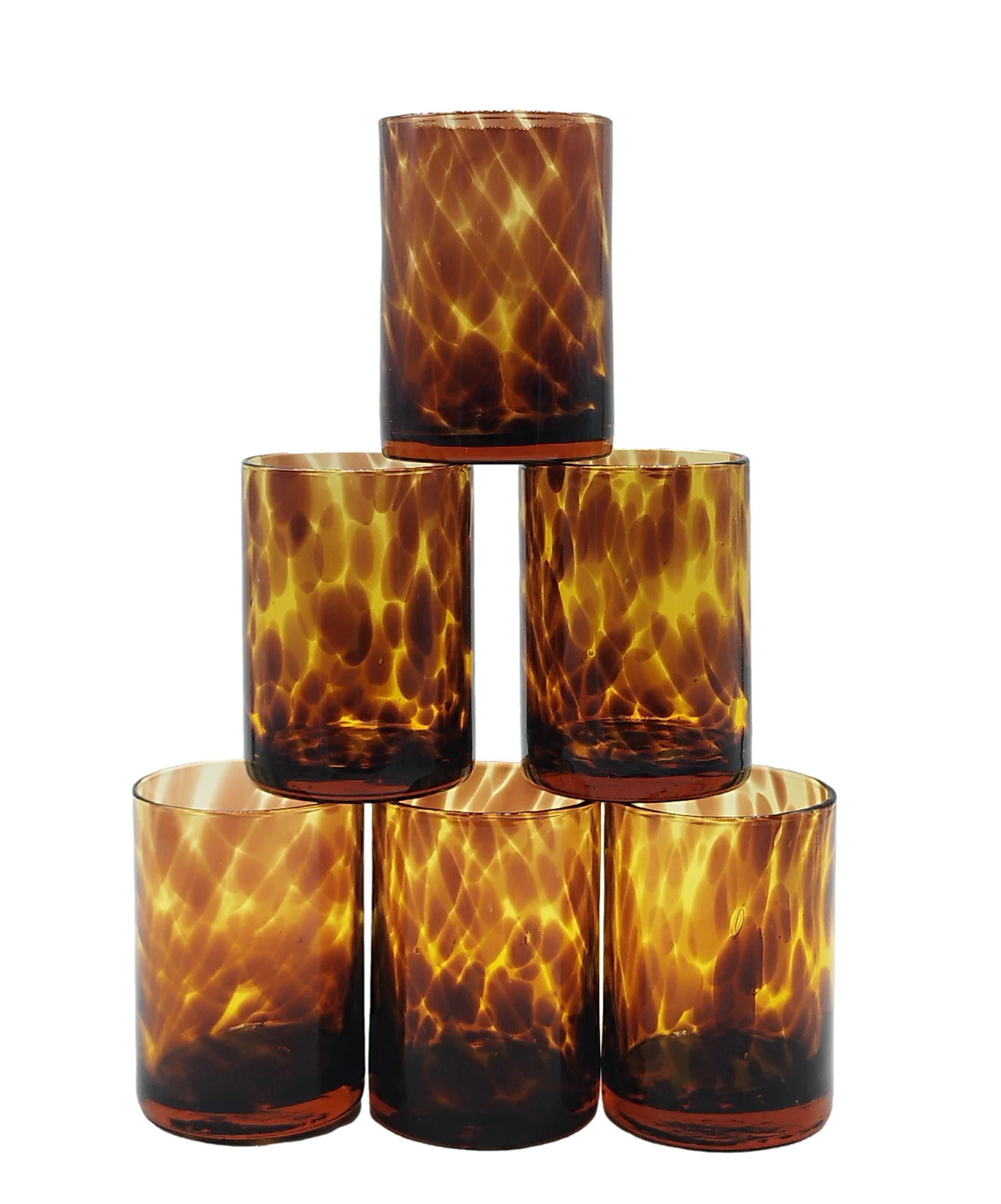 Elegant hand-blown amber glass bar set with tortoise shell motif.
Made of mouth-blown glass, these handmade double tumblers with tortoise shell pattern add depth and texture to any table or bar, and the consistent weight of the glass adds a touch of