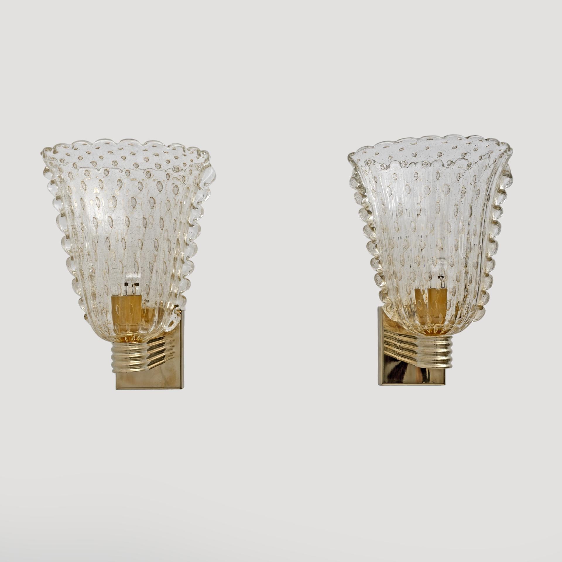 This fabulous pair of Art Deco style Murano glass sconces was made entirely by hand. It is all decorated with the Pulegoso technique. This means it has large air bubbles inside the high-quality blown glass, crafted with 24-karat gold dust