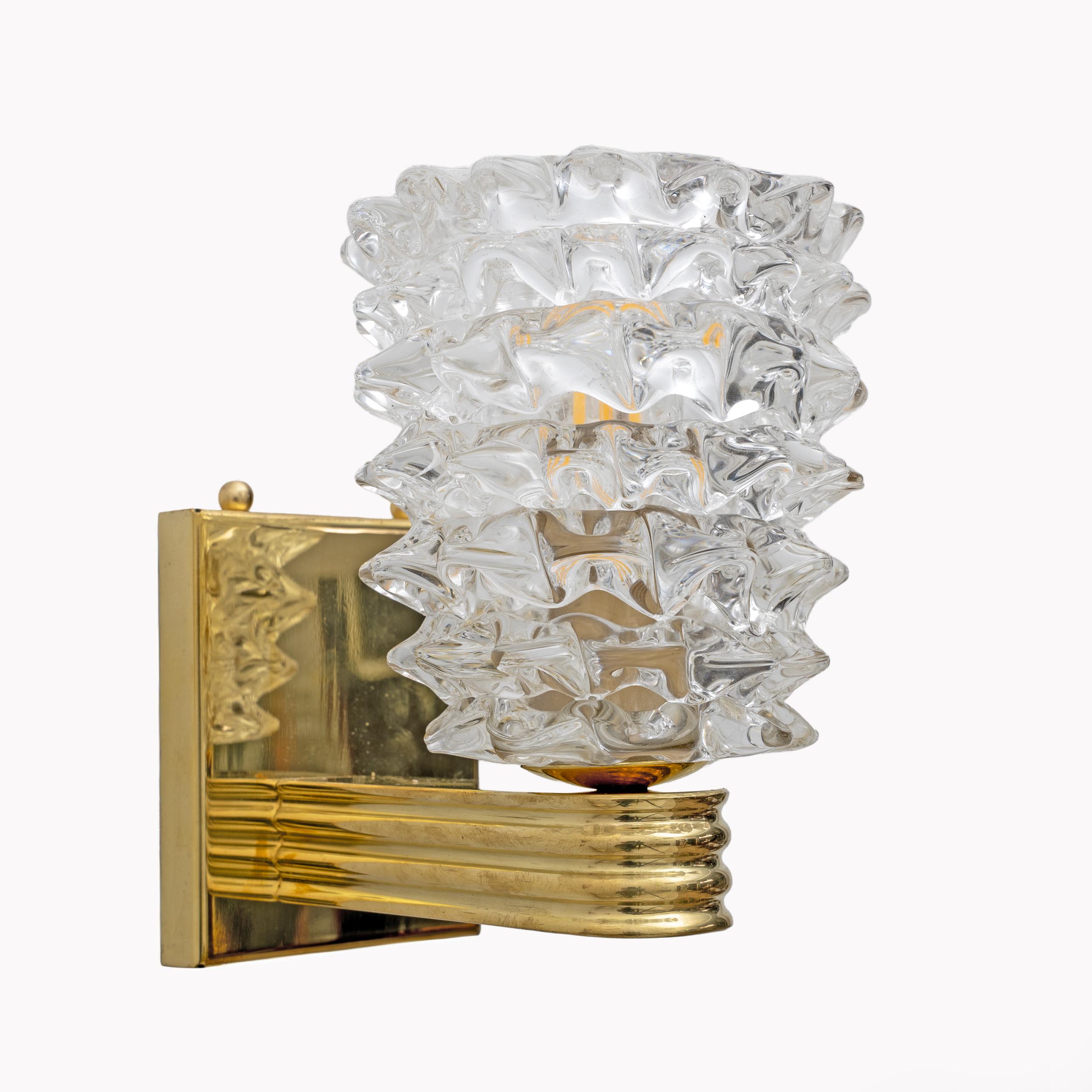 This stunning pair of Murano glass wall lights has been handcrafted using the Rostrato glass technique. This means that each glass segment has been individually fired in relief to achieve a stunning three-dimensional effect. They are mounted on an