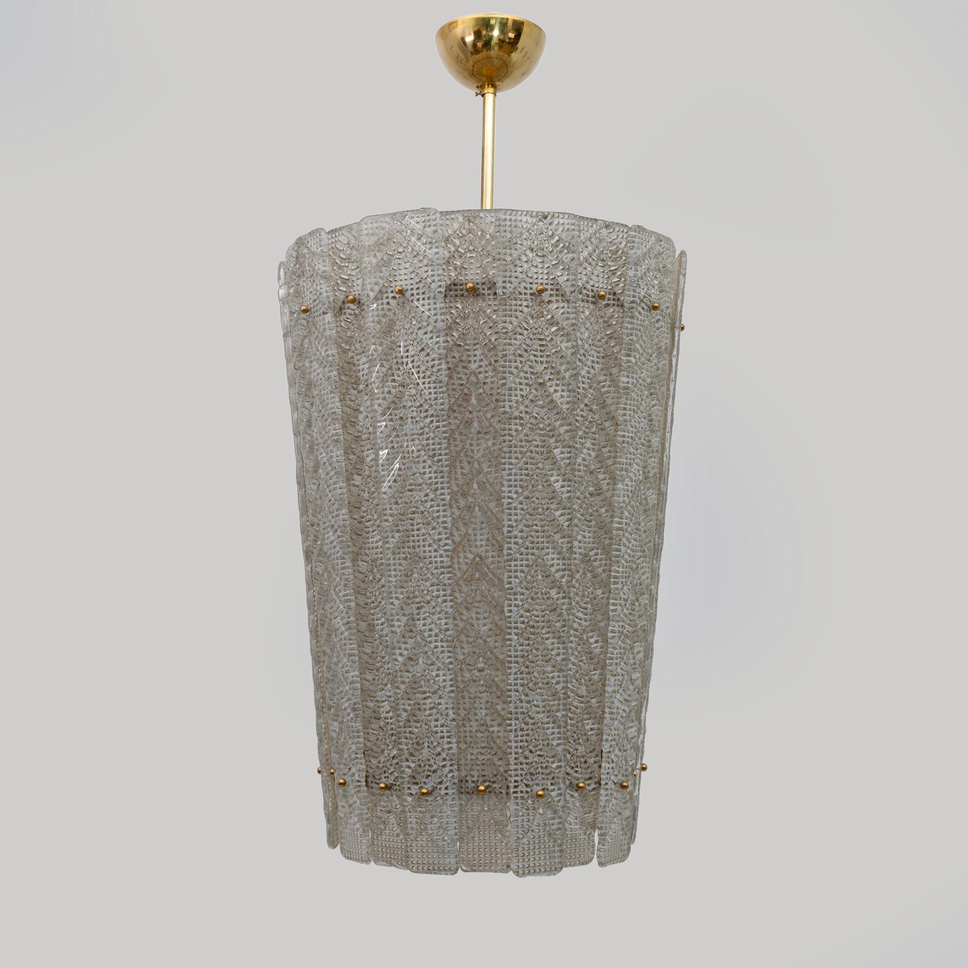This fabulous Art Deco lantern-shaped chandelier is composed of printed and textured glass sheets fixed with brass spheres on a metal and brass structure, made entirely by hand by the master glassmakers of Boarovier & Toso in Murano.
The glass body