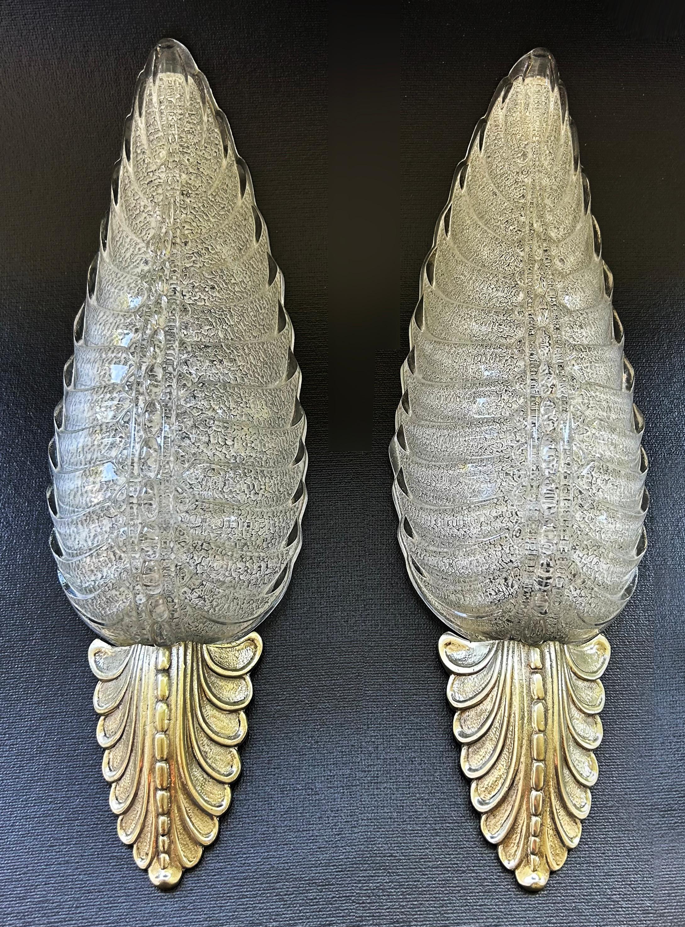  Barovier & Toso Bronze and Murano Glass Leaf Sconces with Gold Infusions

Offered for sale is a pair of Murano glass and bronze Italian Barovier & Toso leaf sconces.  The sconces are hard-wired for American electrical and are ready to hang.  They