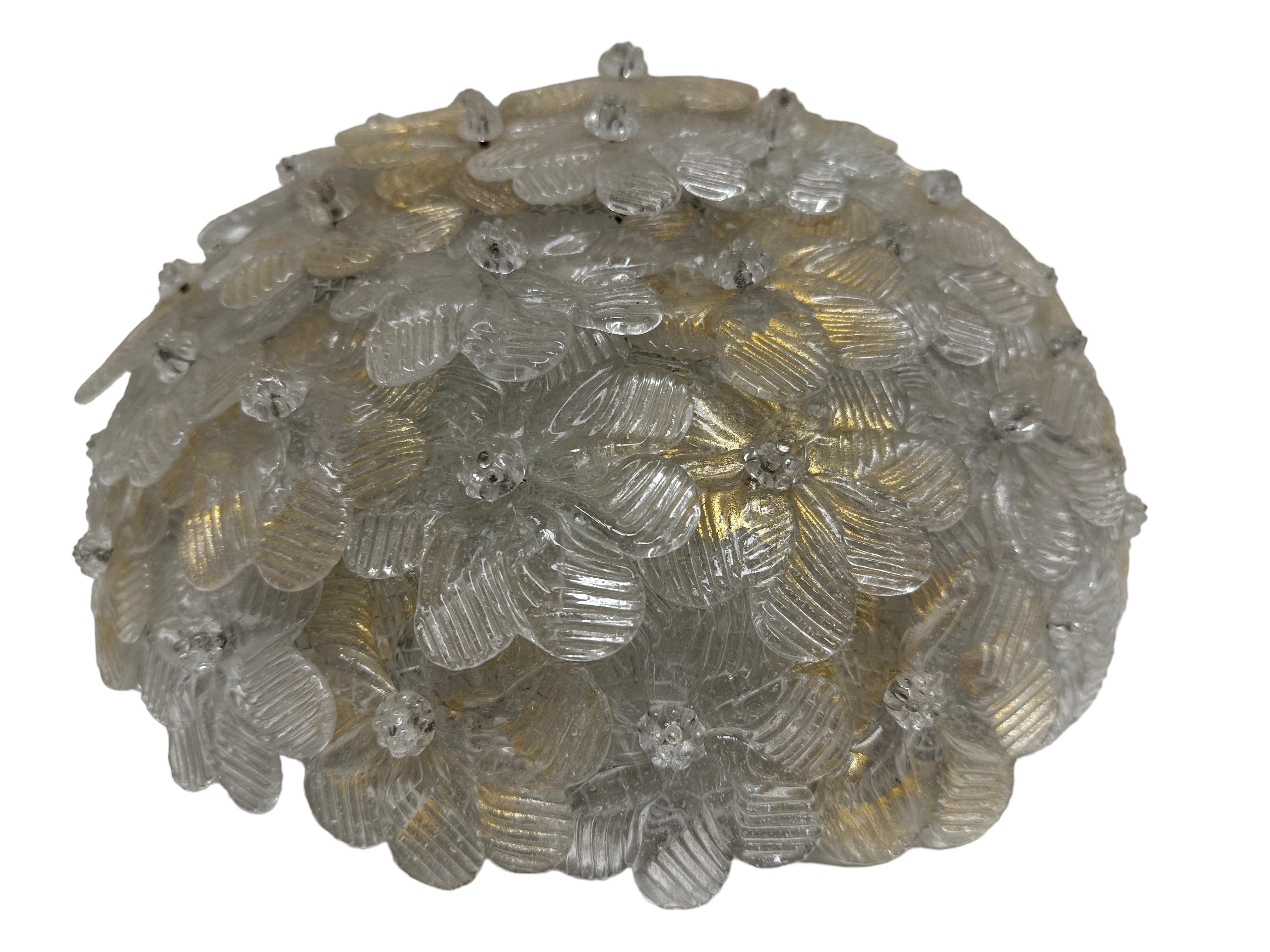 A hand blown Italian flush mount chandelier featuring overlapping crystal flowers, gold with 23-carat gold leaf fleck inclusions, mounted on a basket frame. The fixture requires two European E14 / 110 volt candelabra bulbs, each bulb up to 60 watts.