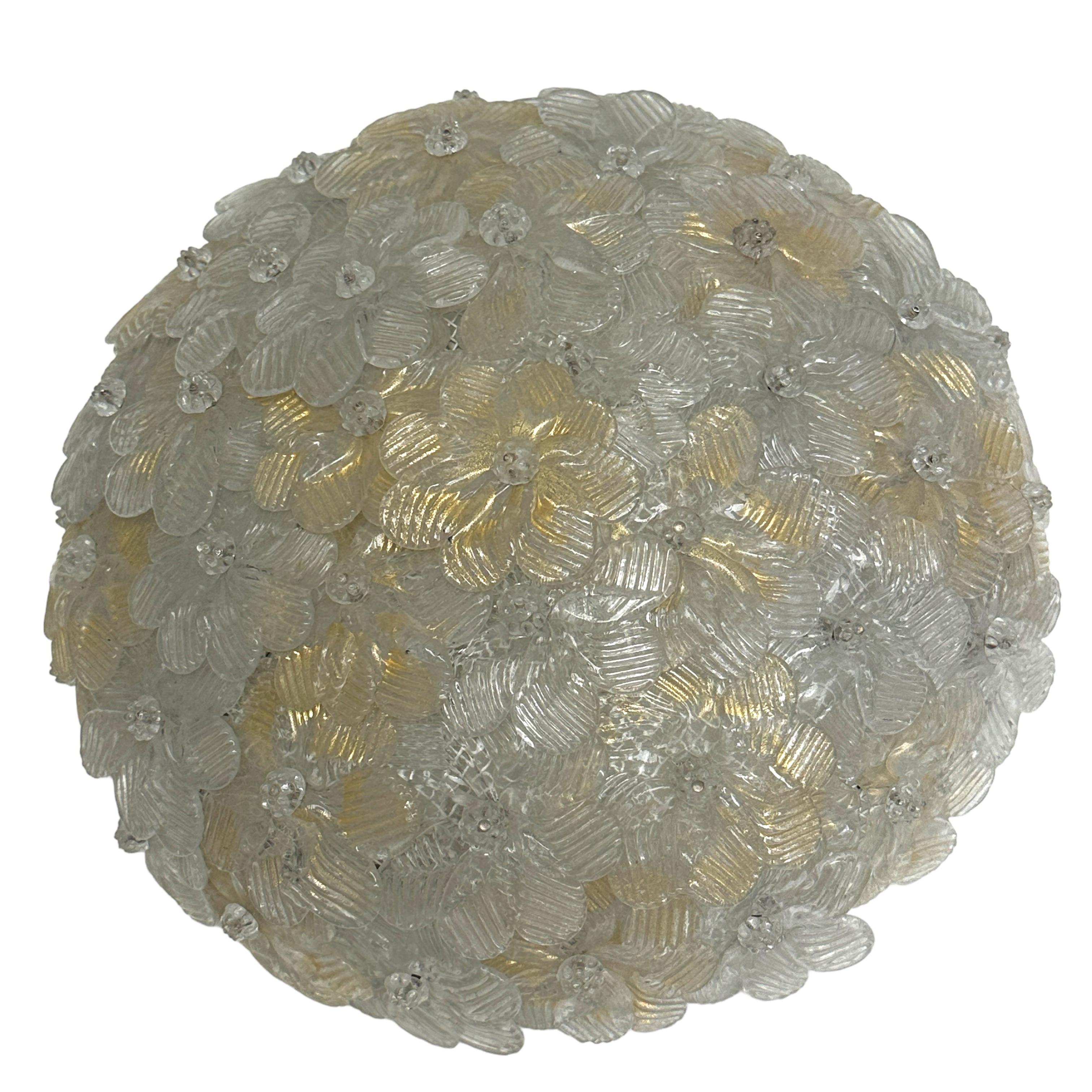 A hand blown Italian flush mount chandelier featuring overlapping crystal flowers, gold with 23-carat gold leaf fleck inclusions, mounted on a basket frame. The fixture requires two European E14 / 110 volt candelabra bulbs, each bulb up to 60 watts.