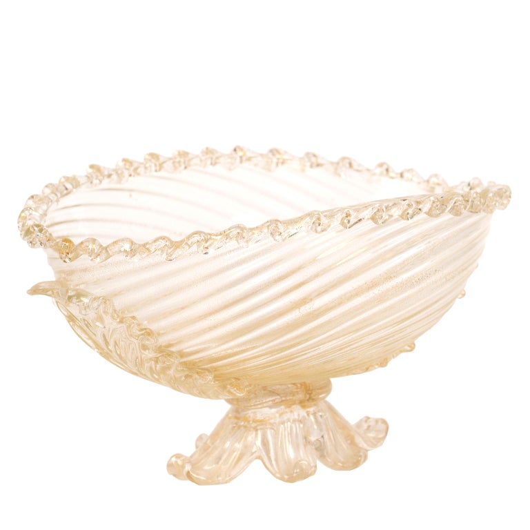 This delicately designed clear glass Murano bowl with gold infused highlights has many beautiful details from its splayed foot, and ribbed center, to its twisted top.
It is in excellent vintage condition with no
issues.