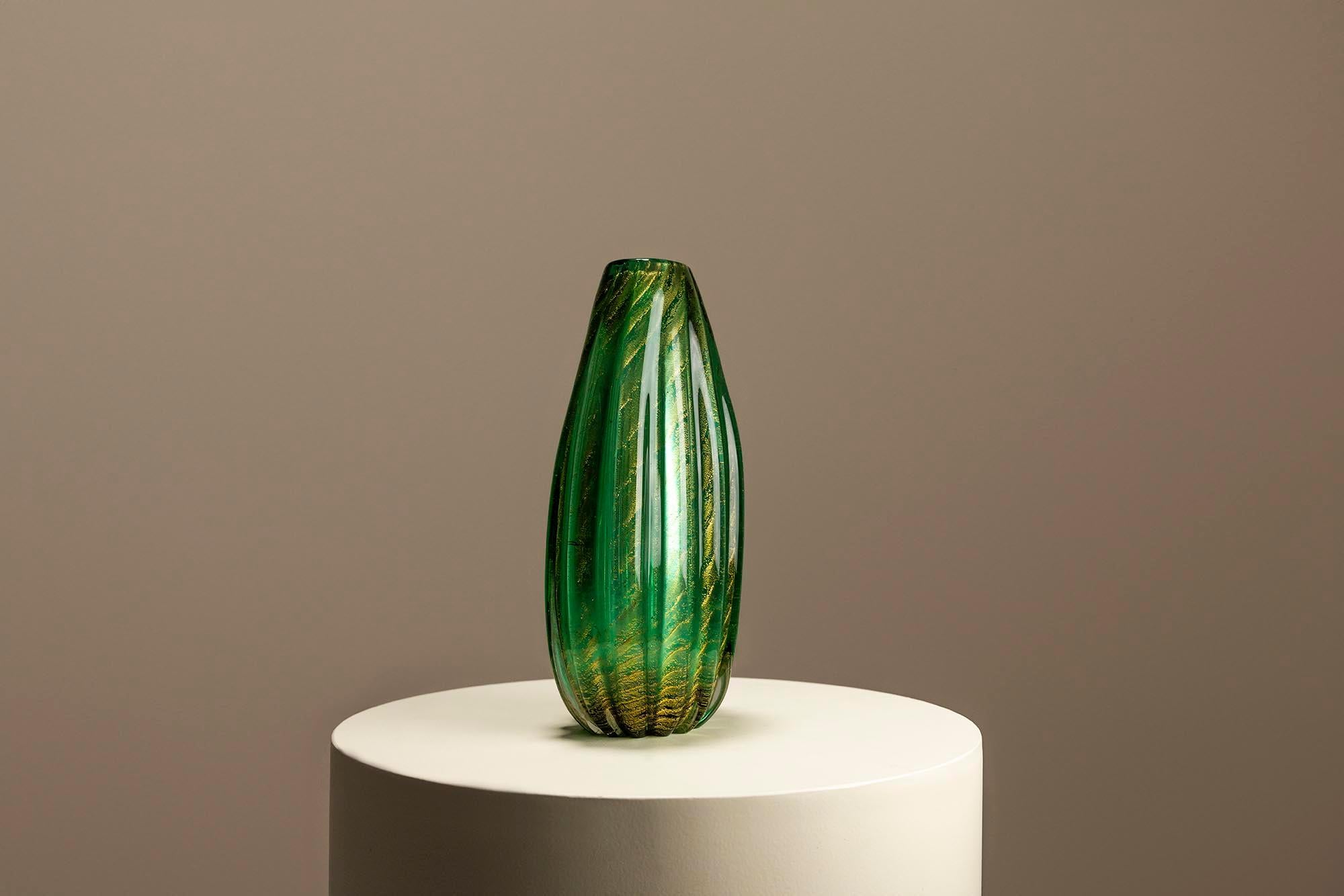 ie grüne Vase Coronato d'oro von Barovier & Toso ist ein Symbol für zeitlose Eleganz in der Welt des Murano-Glases. Die ovale Form, ein Wunderwerk der Handwerkskunst, bezaubert mit ihrer ätherischen Ausstrahlung und verkörpert die jahrhundertealte