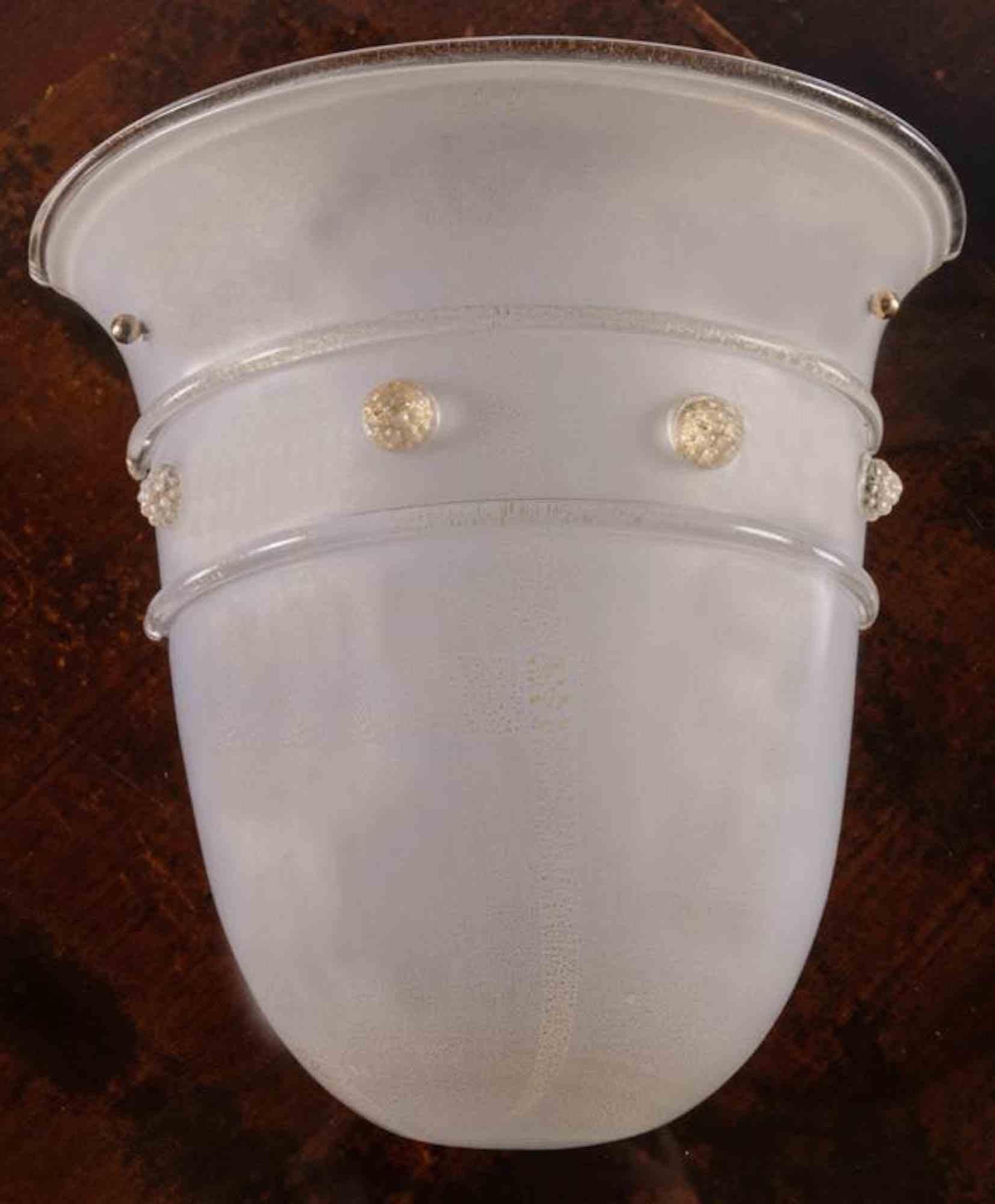 Barovier & Toso, Large one-light sconce in white milky glass, Murano, 1980s.

Inclusions in gold dust, hot-applied relief decorations, bears the manufacturing brand inside.

H cm 31x32x15.5 

Good condition.