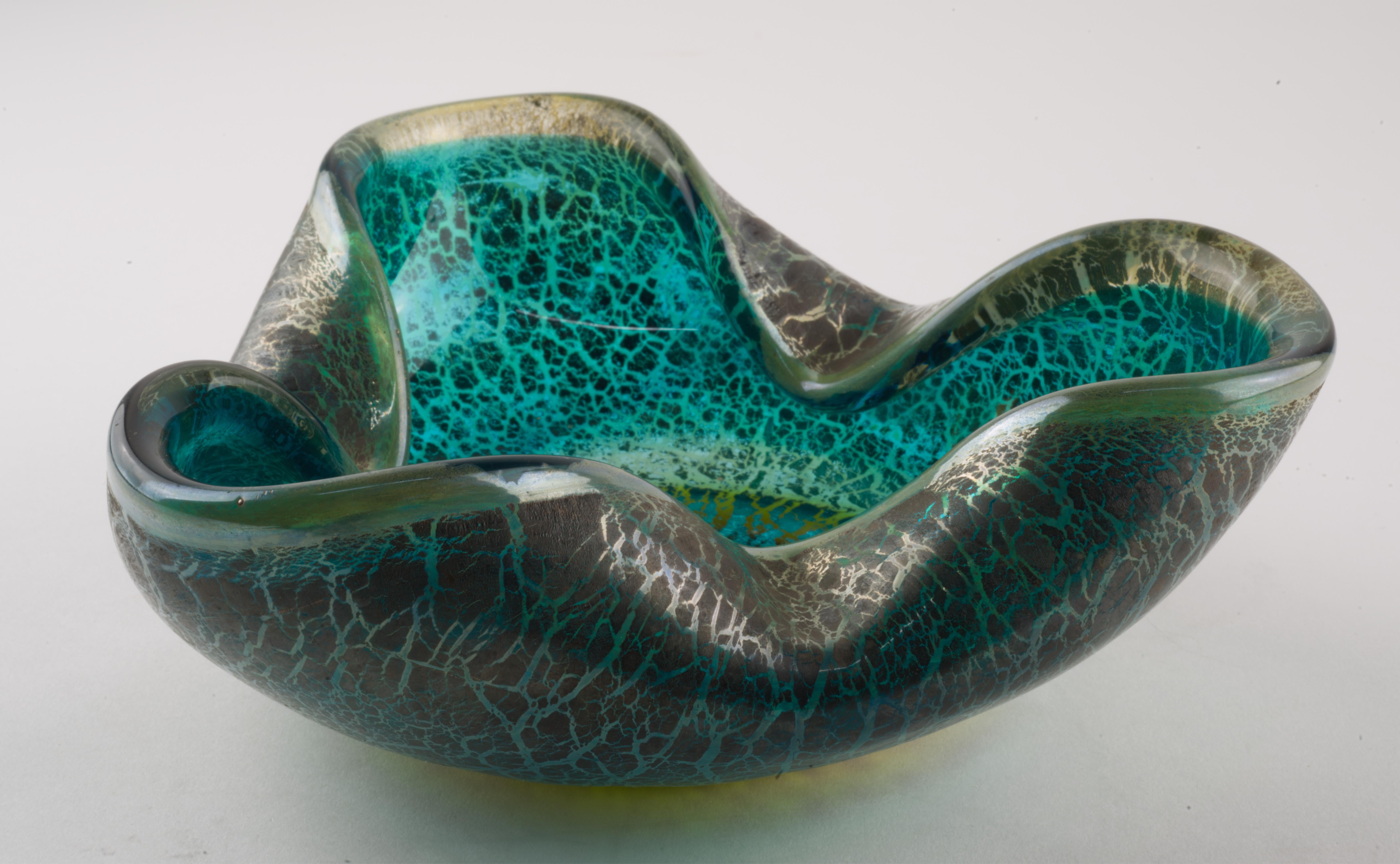  Rare et inhabituel bol ou cendrier en verre d'art de Murano a été réalisé avec une couche de feuille d'argent éclatée sur un verre bleu et transparent et une base en verre ambré. 

L'attribution correcte a été faite après avoir étudié de nombreux
