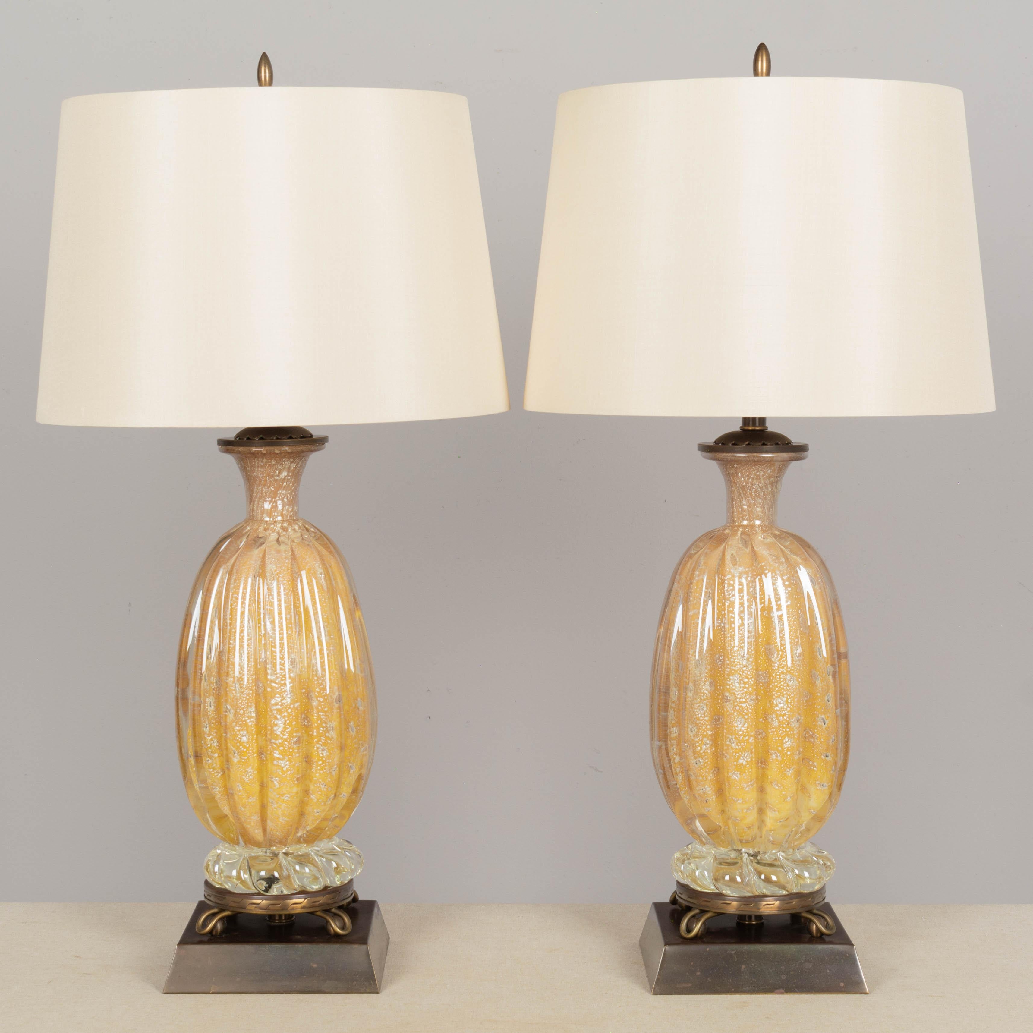 A pair of Mid Century Murano glass lamps by Barovier & Toso. Beautiful pineapple gold color with controlled bubbles and silver inclusions. Original brass base and hardware. Nice aged bronze colored patina with minor pitting. All original. Rewired