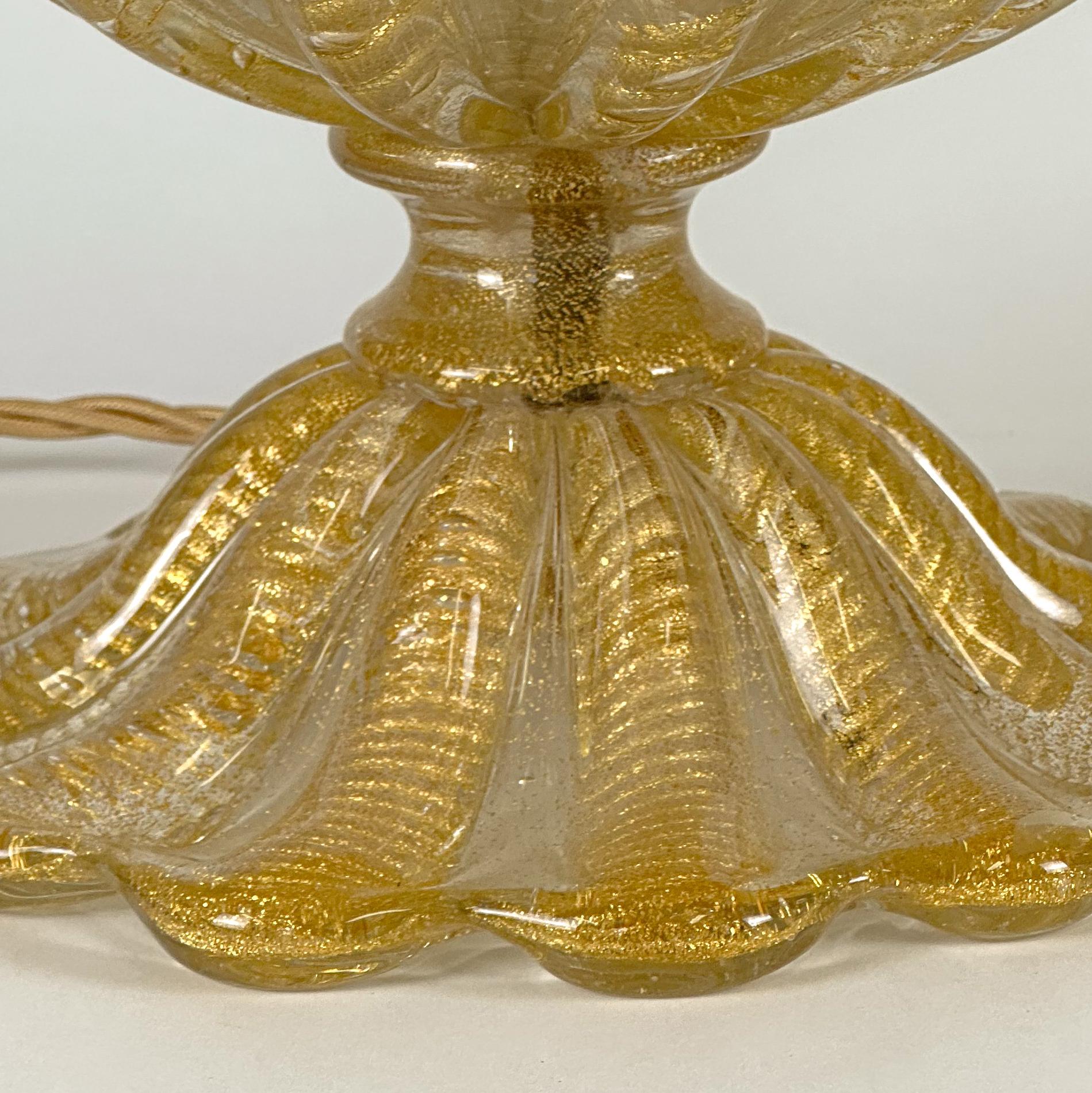 A gold Murano glass table lamp by Barovier & Toso, crafted in the 1950s.

The design employs the Cordonato D’Oro technique—an intricate process in which 24-karat gold leaf is suspended in glass to create a rope-like motif that traces each rib of the