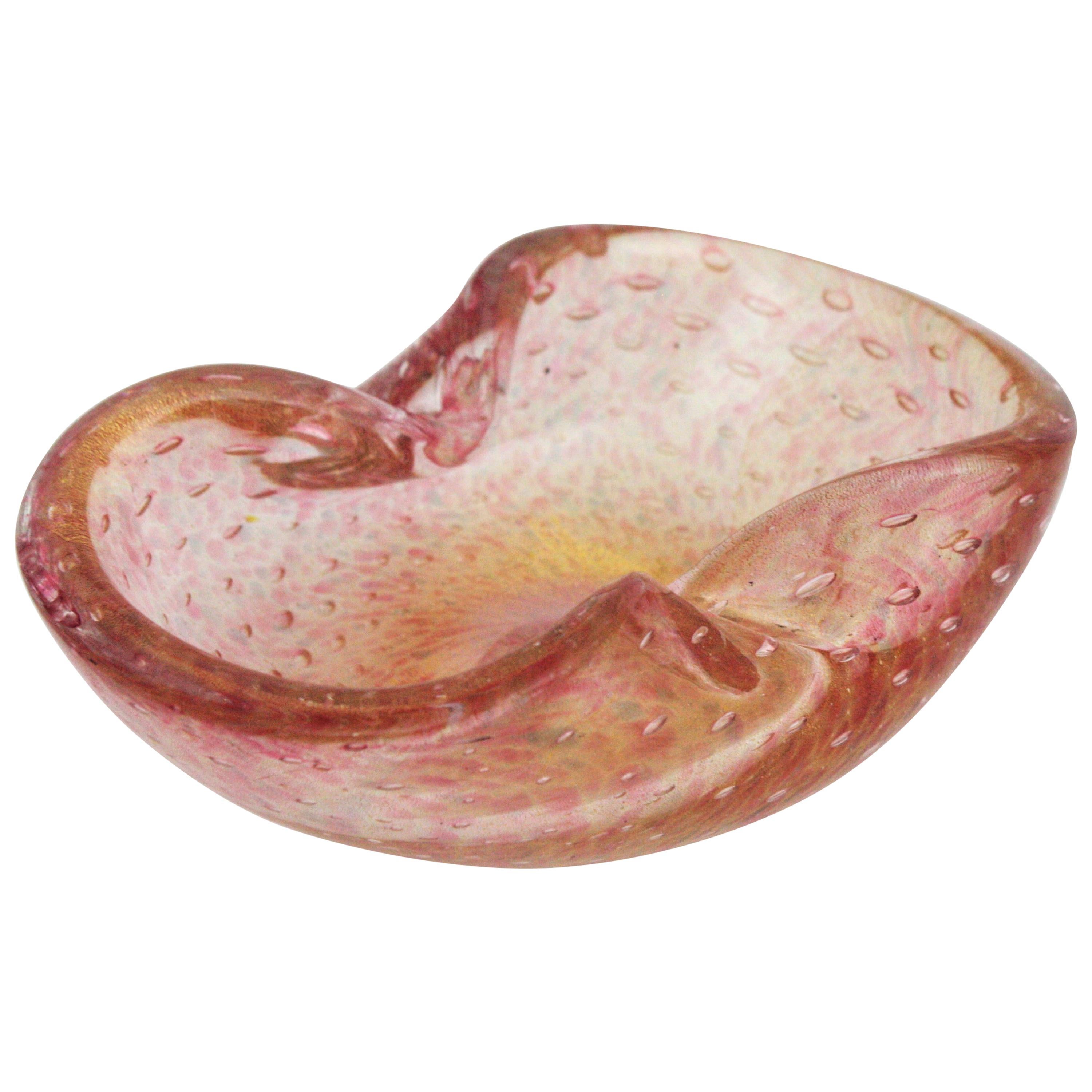Incroyable cendrier / bol en verre de Murano soufflé à la main avec des mouchetures d'or et des bulles d'air contrôlées. Attribué à Barovier&Toso. Italie, années 1950.
Taches de verre rose et gris et verre transparent. Il est doté de centaines de