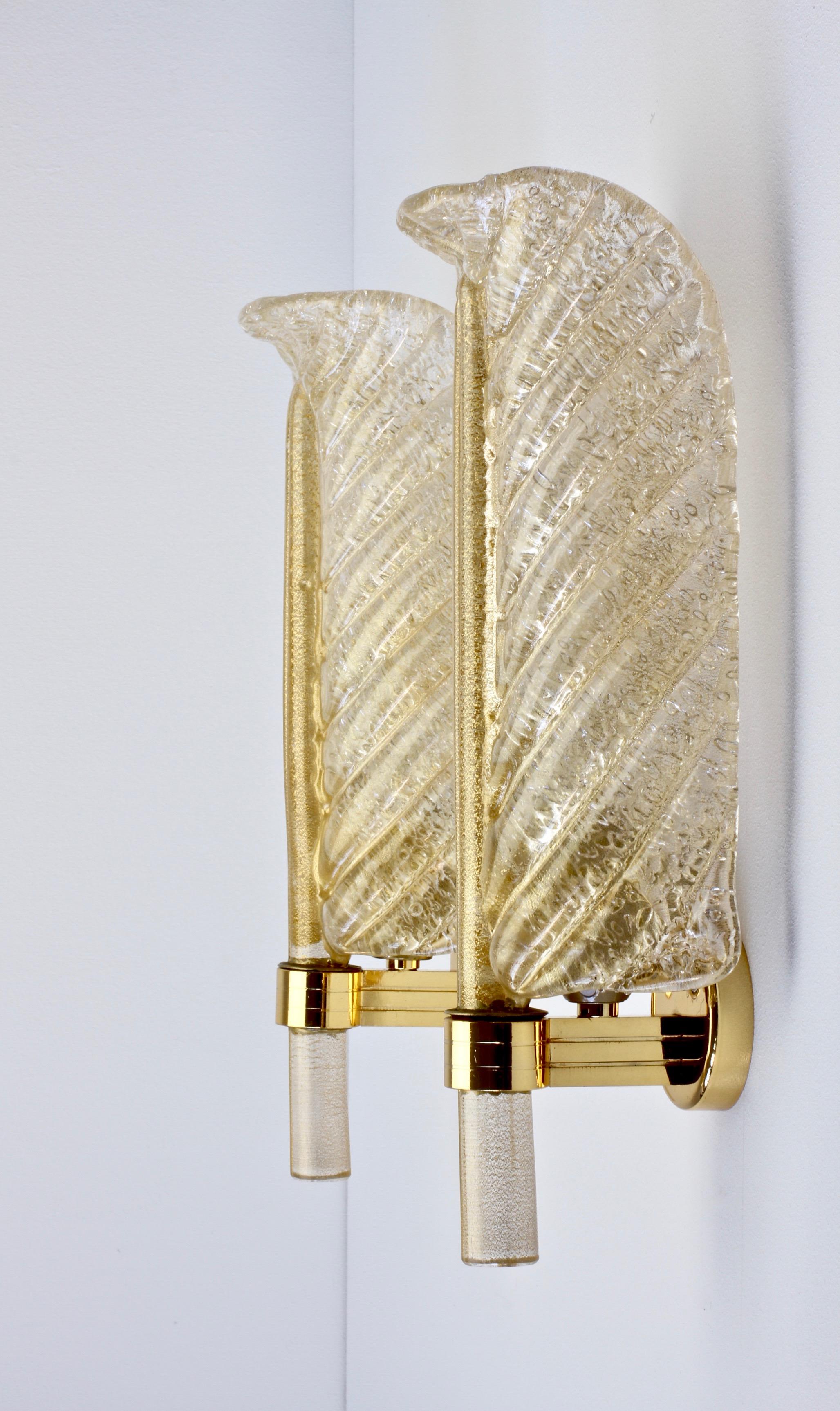 Barovier e Toso pair of Venetian neoclassical style Murano glass leaf sconces or wall-lights made in Italy, circa 1980s. Made of textured clear glass with 24-carat gold inclusions handmade and shaped in to the form of curved leaves. Suspended on