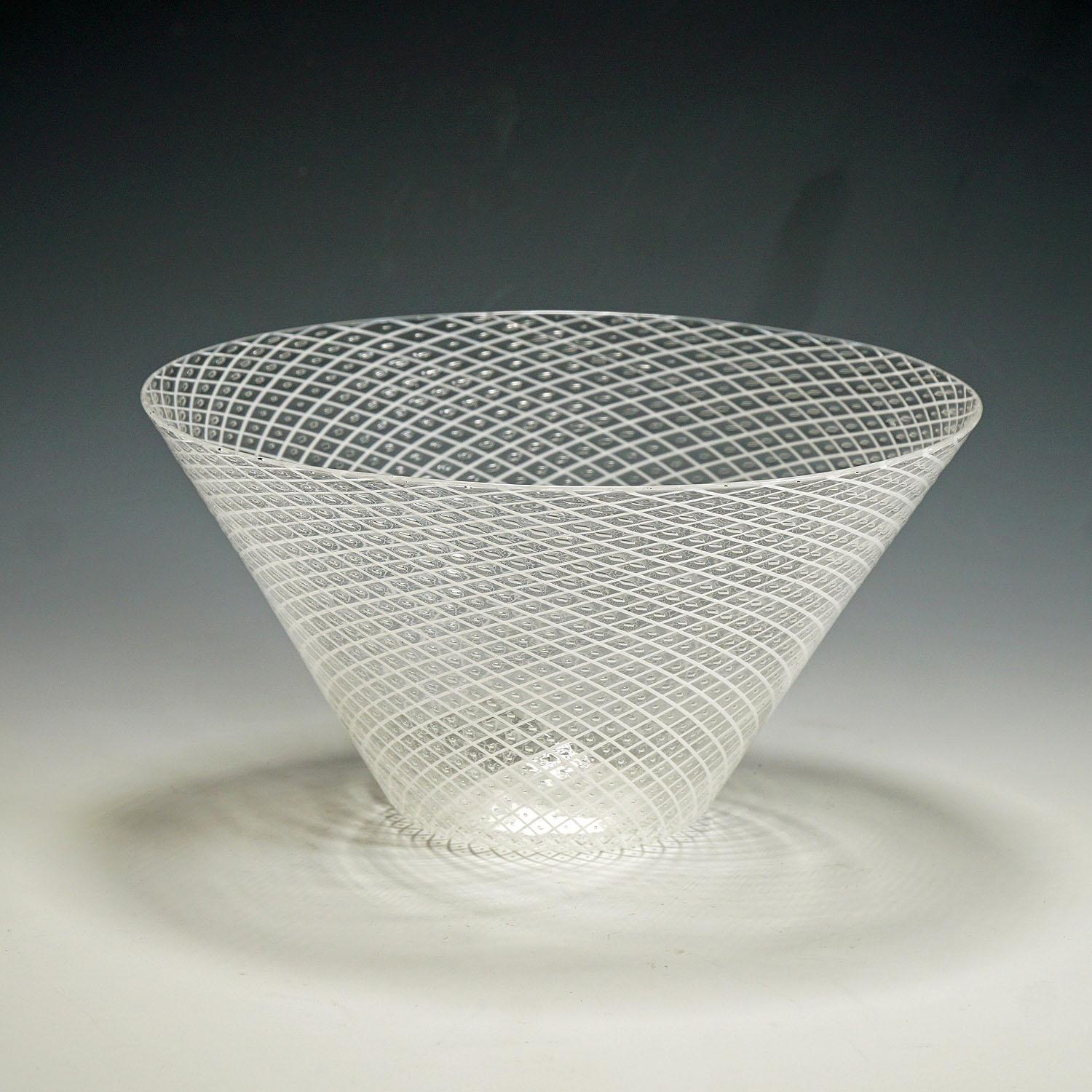 A vintage Murano art glass bowl in reticello technique. Thin clear glass with crossed white glass threads and regular air bubbles inbetween. Manufactured by Barovier & Toso around 1950s. Polished pontil mark and incised signature 