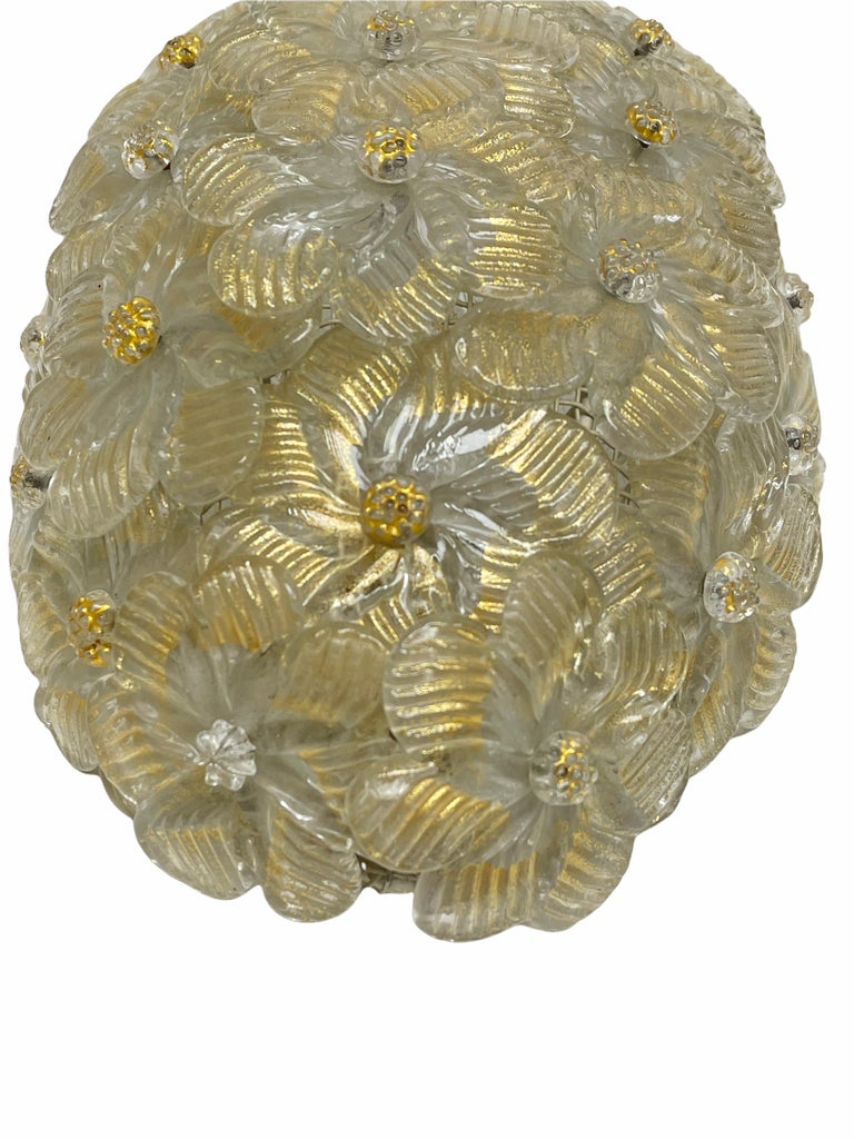 A beautiful hand blown Italian Sconce featuring overlapping crystal flowers, gold with 23-carat gold leaf fleck inclusions, mounted on a basket frame. The Fixture requires a European E14 / 110 volt candelabra bulb, up to 60 watts.