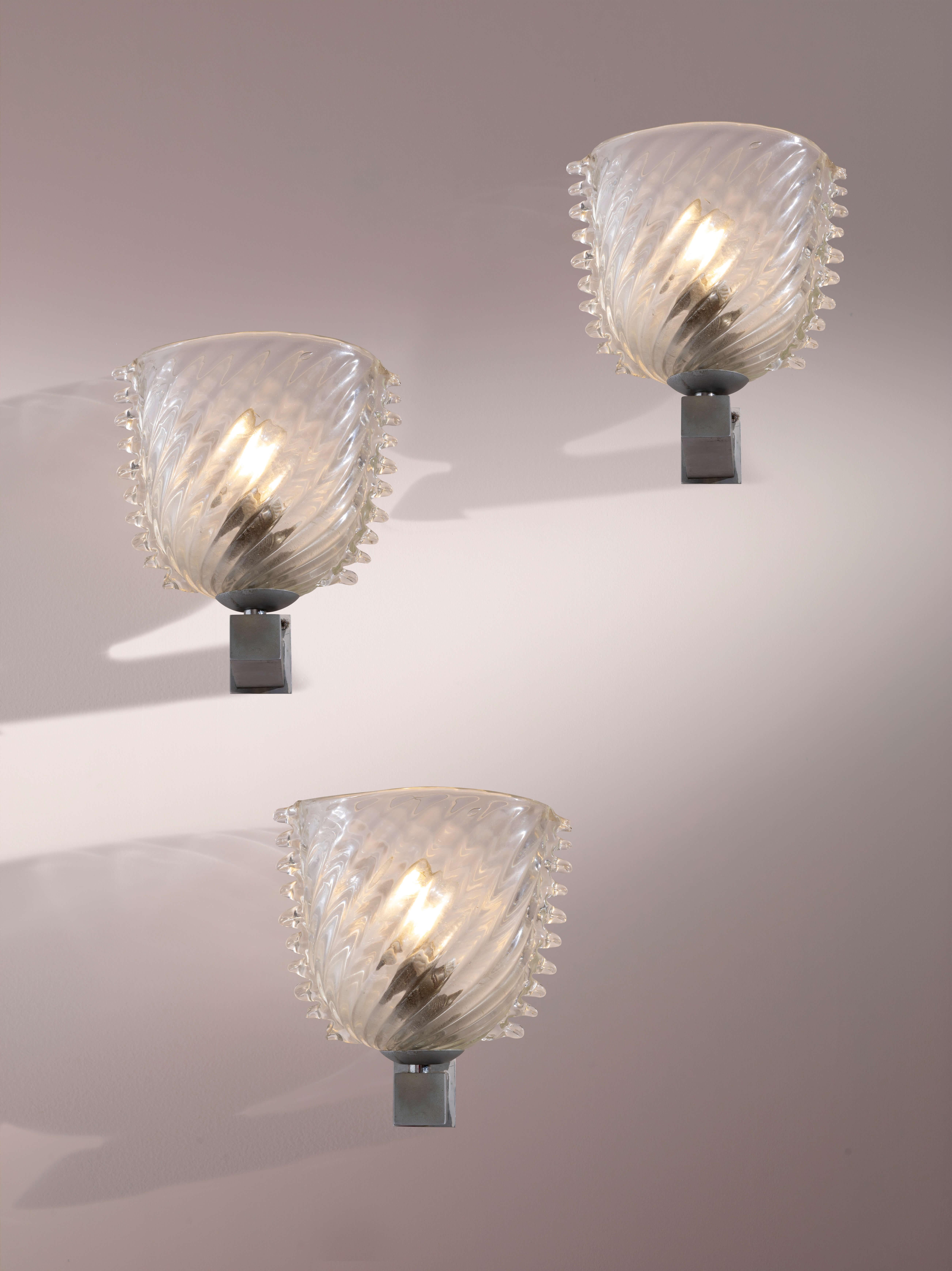 Ensemble exquis de trois appliques en verre de Murano et laiton nickelé, Manufacture Barovier&Toso, Murano, années 1940

Cet élégant groupe de trois appliques représente la plus belle expression de l'art du verre de Murano, fabriqué dans les années