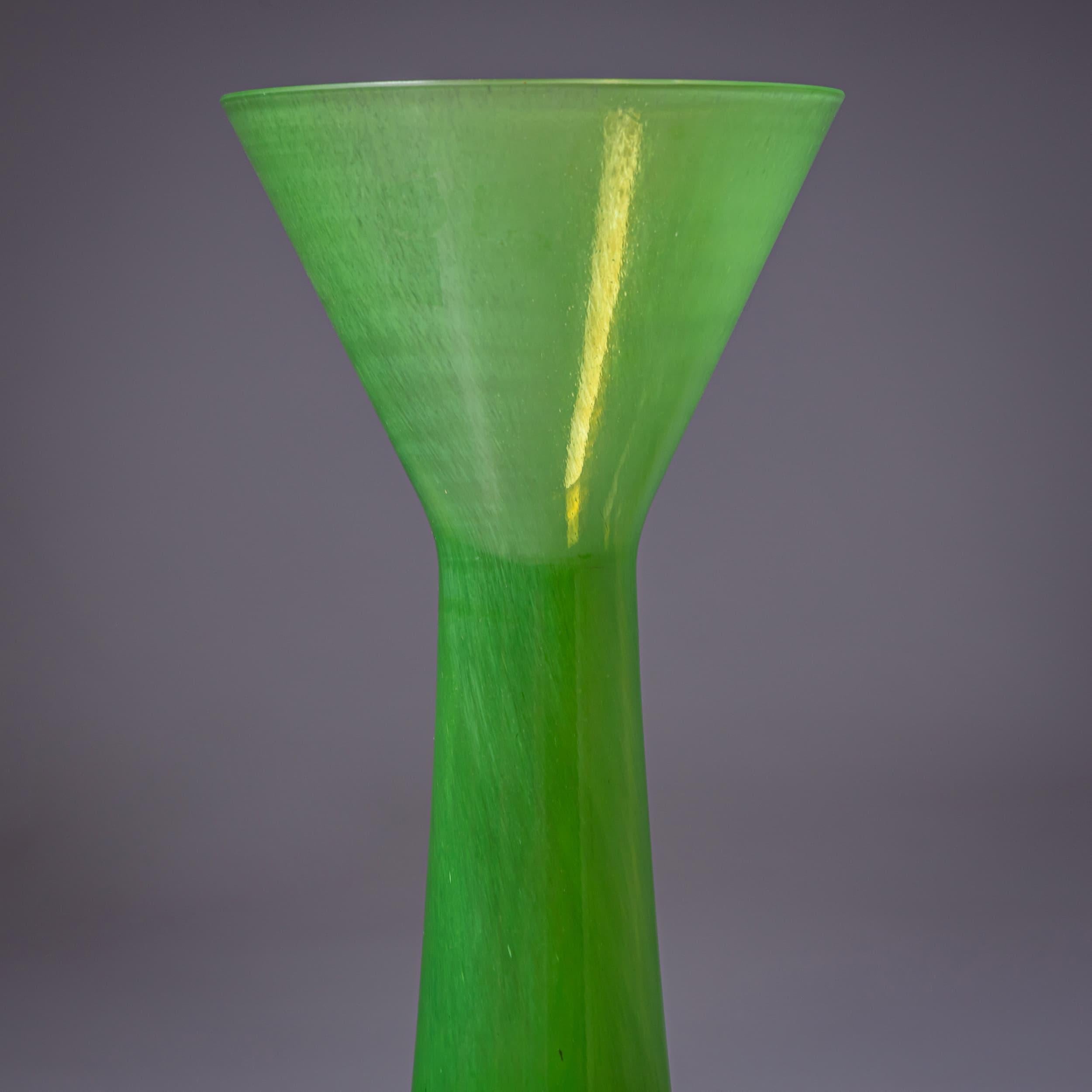 Vaso da studio di grande effetto della serie B.A.G. (Barovier Art Glass), Murano, Italia, fine del XX secolo. Realizzato in vetro verde brillante, il vaso presenta un fusto affusolato con una bocca a tromba svasata. L'audace base gialla è accentuata