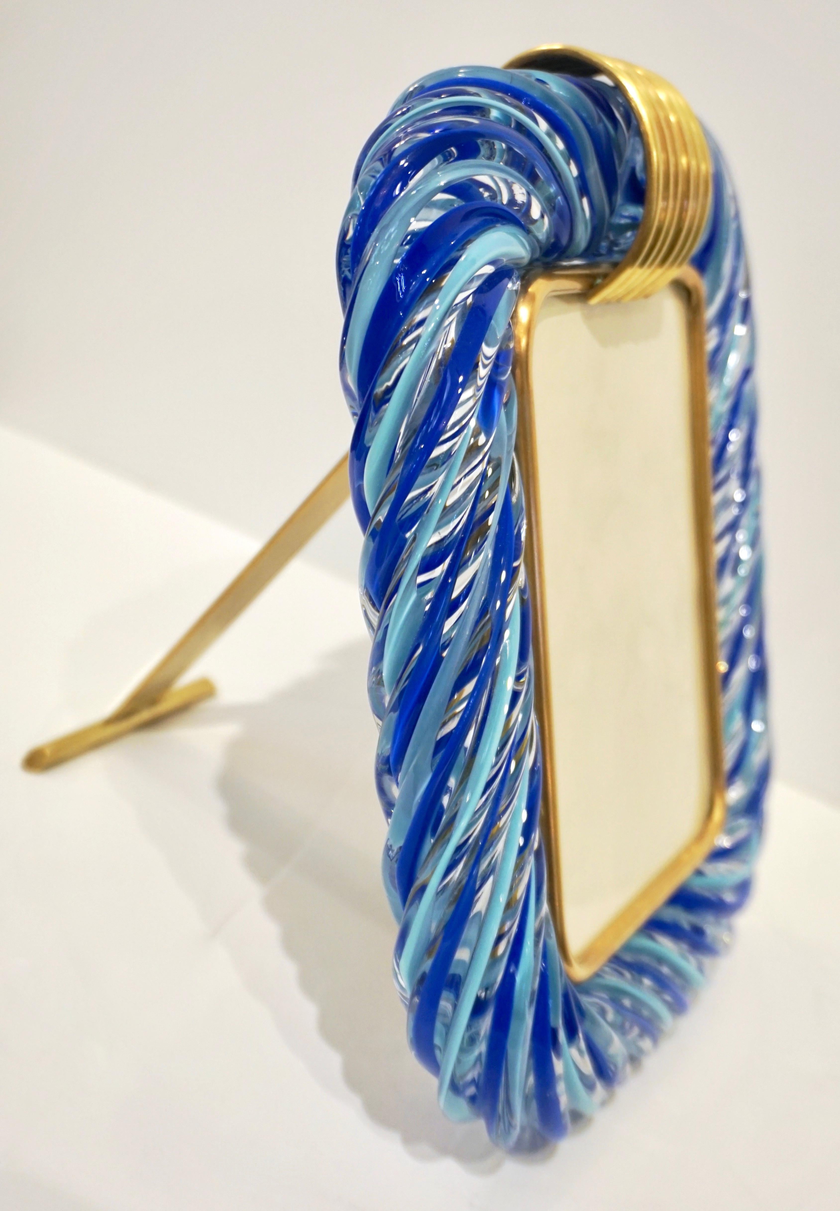 A 1970s modern design Venetian picture frame in thick blown Murano glass by Barovier & Toso, signed piece, in warm shades. The decoration of the highest quality, with the incalmo of waved filigrana creating a light and dark blue ribbon inside the
