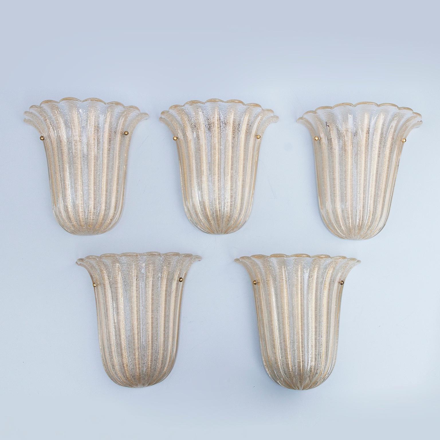Set of three Murano glass sconces made by Barovier e Toso, Italy, 1960s.
The glass is hand blown and is infused with gold using the Foglia d’oro technique, the reverse side of the sconces were made using the Rugiada technique with minute fragments