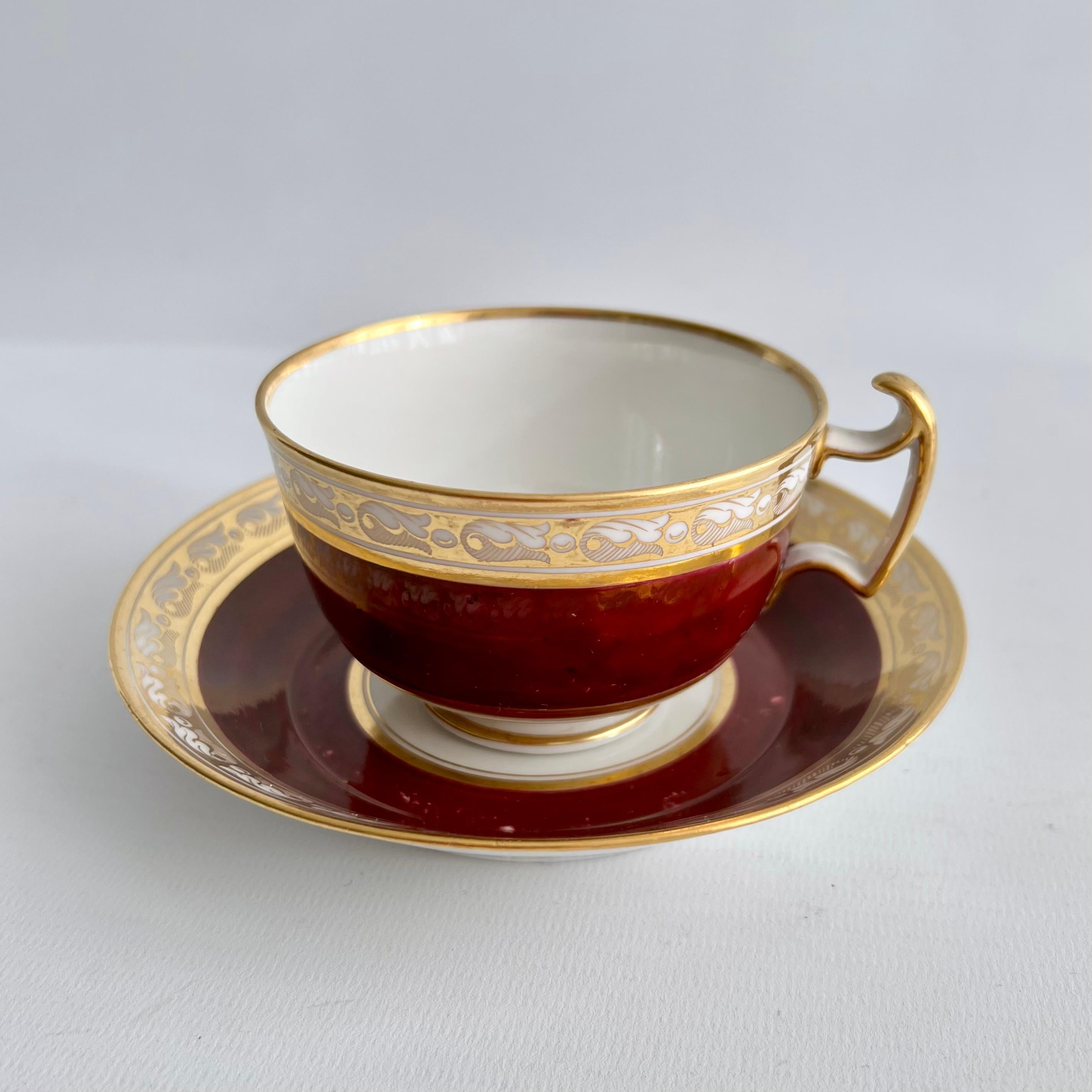 This is a beautiful true trio made by Barr, Flight & Barr, consisting of a teacup, a coffee can and a saucer. The set has a deep maroon ground and a very gracious gilt neoclassical band around the rims.

In the early 19th Century cups and saucers