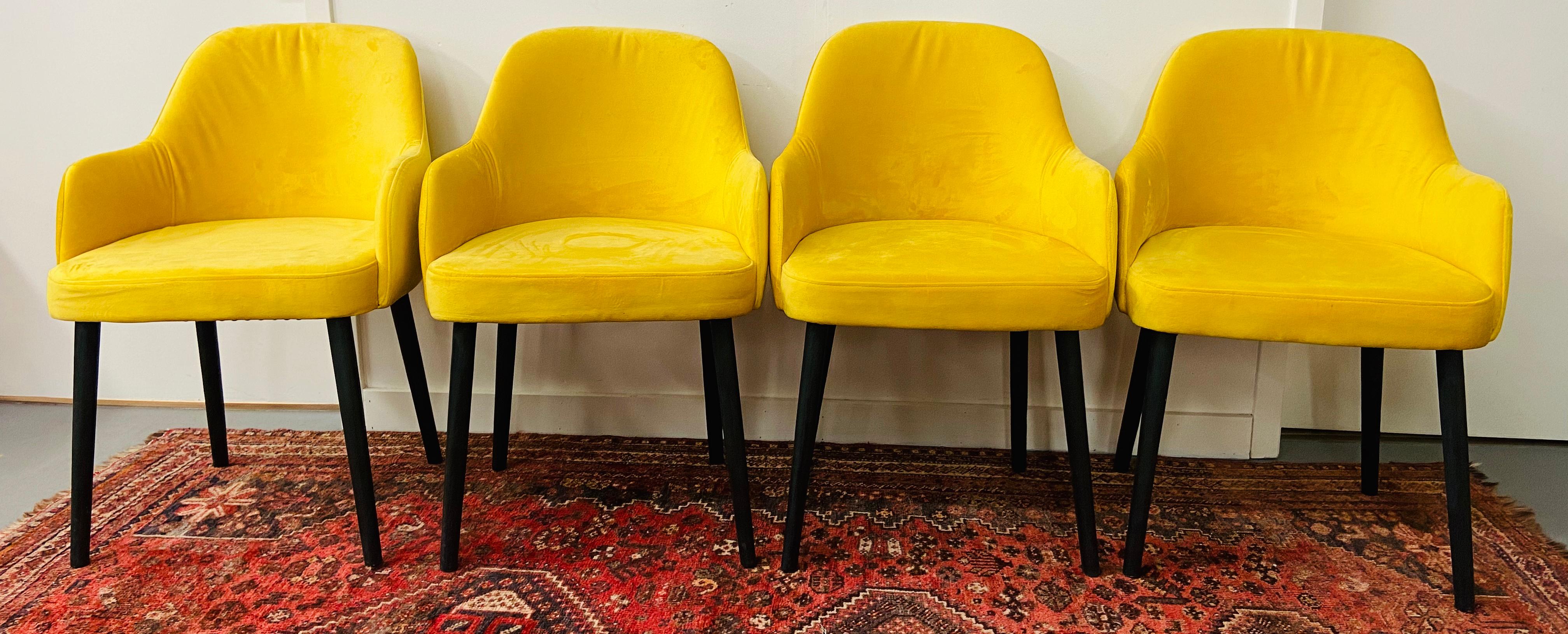 A very chic and comfortable set of 4 Mid-Century Modern barrel back armchairs. The chair is handmade and have a new suede upholstery. The cheerful mustard yellow color is a bold statement and very modern and stylish. The chairs are the perfect