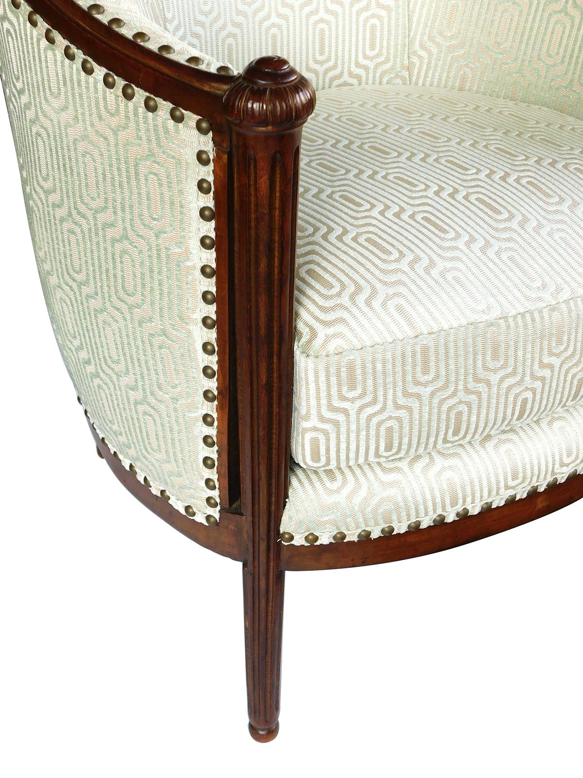 with sloping in-curved back over a loose cushion seat flanked by fluted supports capped with carved snail shells.