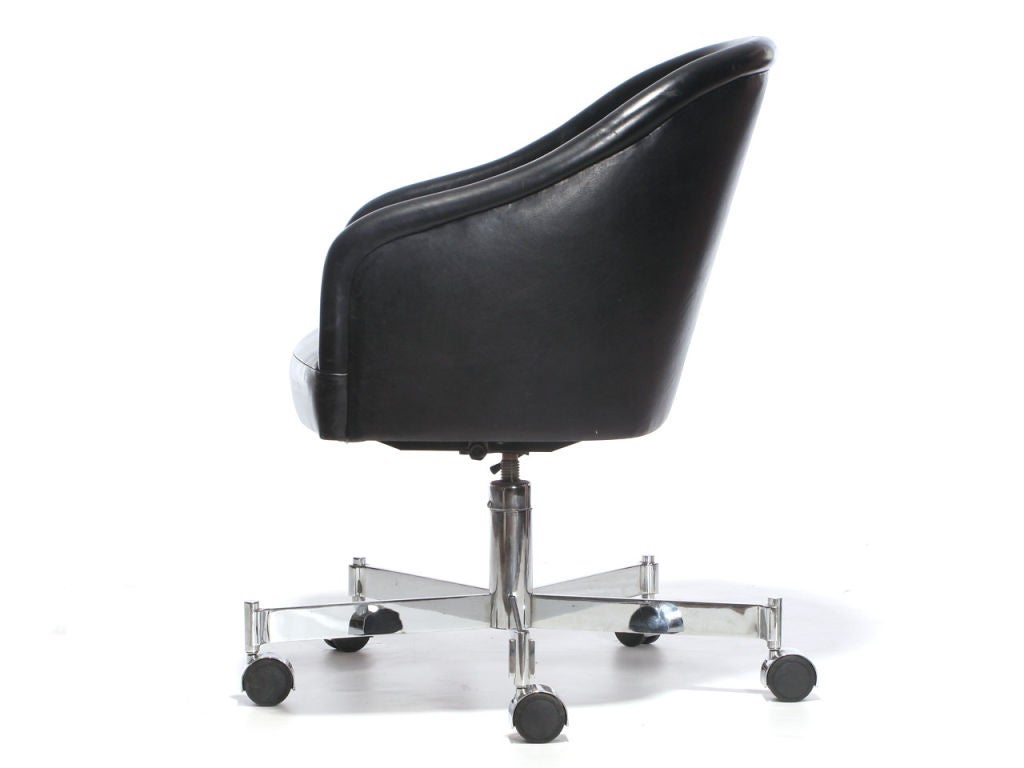 A barrel-back desk chair with the original channel-stitched black leather upholstery, on an X-form caster base. Please inquire for upholstery options.