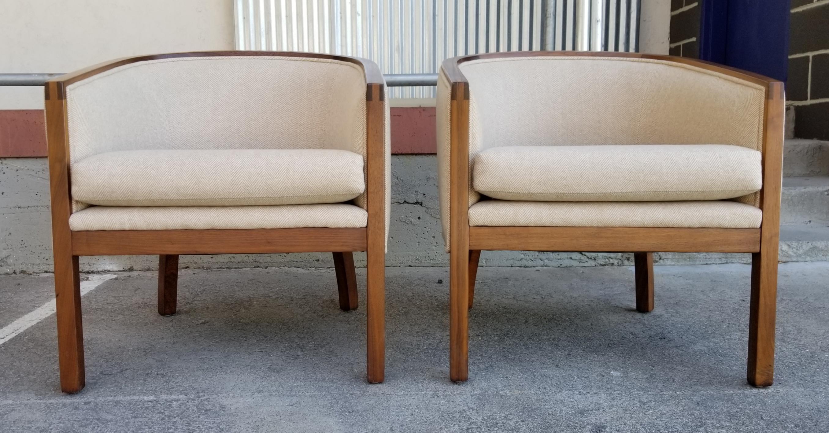 A pair of 1970's era barrel back lounge chairs with solid black walnut frames. Finger-joint detail at front of arms. Fine vintage condition with recent re-upholstery. Comfortable, diminutive size. Quality materials and craftsmanship.