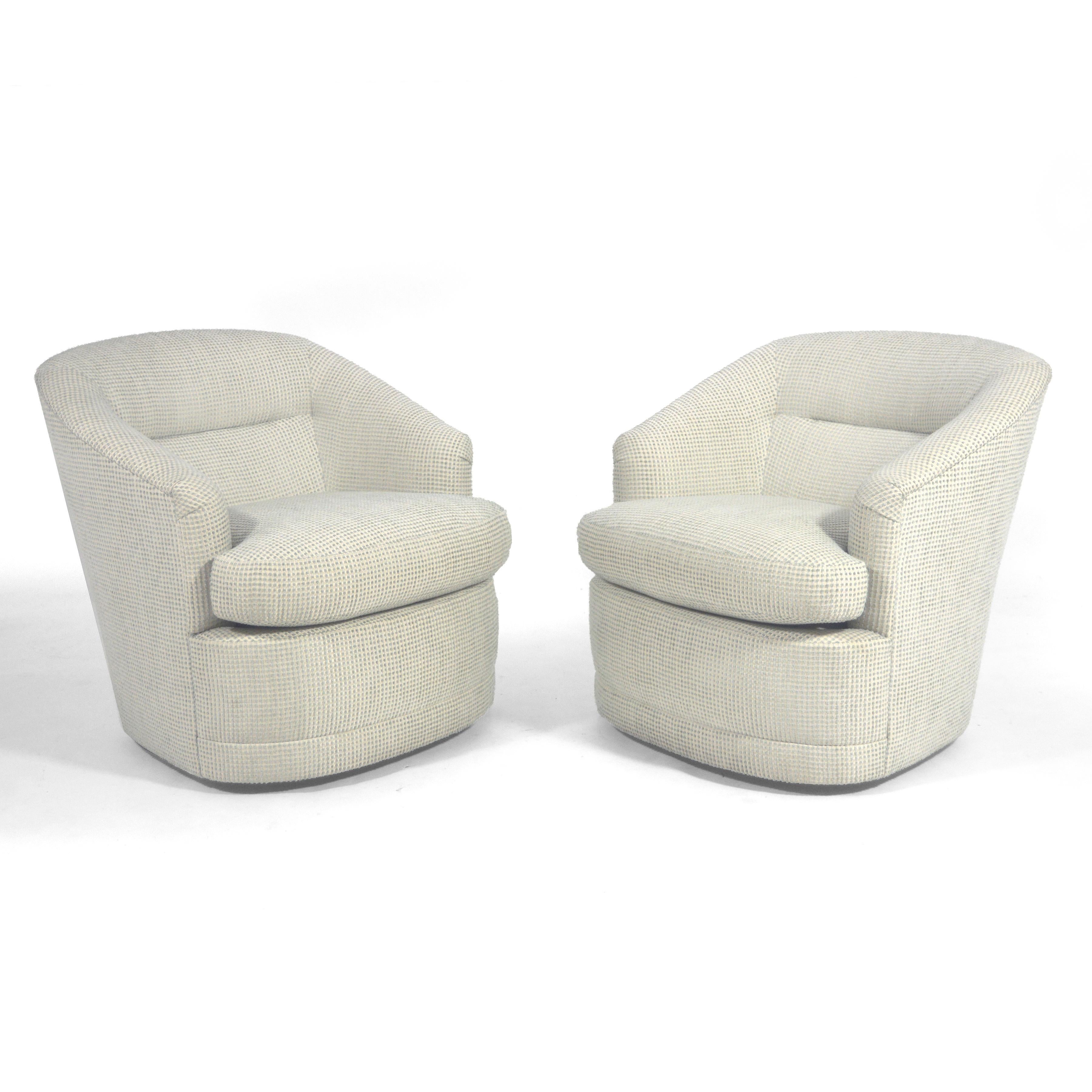 These two handsome and well made barrel back chairs are unmarked, but very similar to designs by Milo Baughman. Deep, comfortable seats with swivel function, they are upholstered in a handsome textured fabric.
 