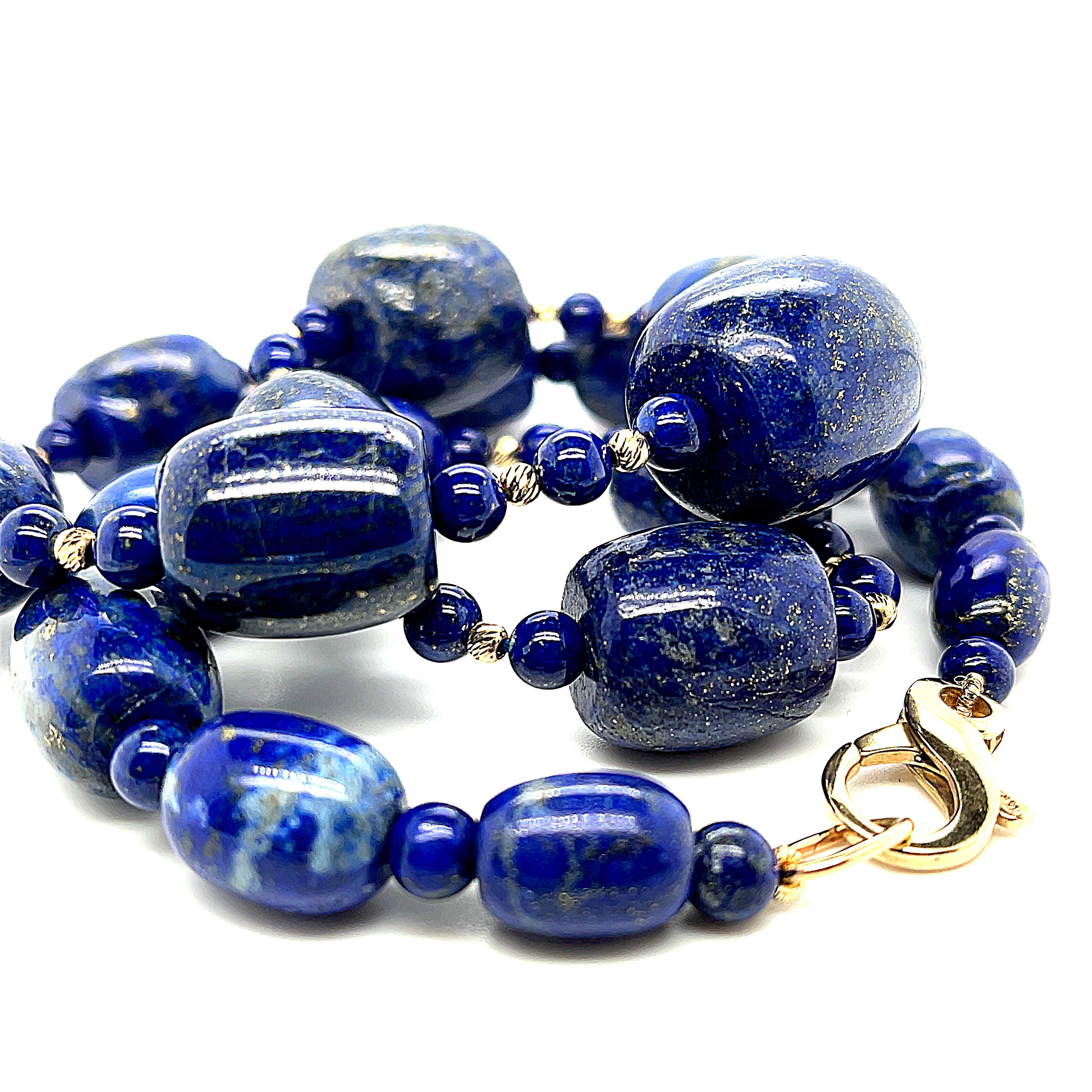 This impressive beaded necklace features rich, violetish blue lapis lazuli beads in large, graduating barrel shapes! The barrel shapes have been arranged and strung on silk thread, accented with perfectly uniform lapis round beads and bright, 14k