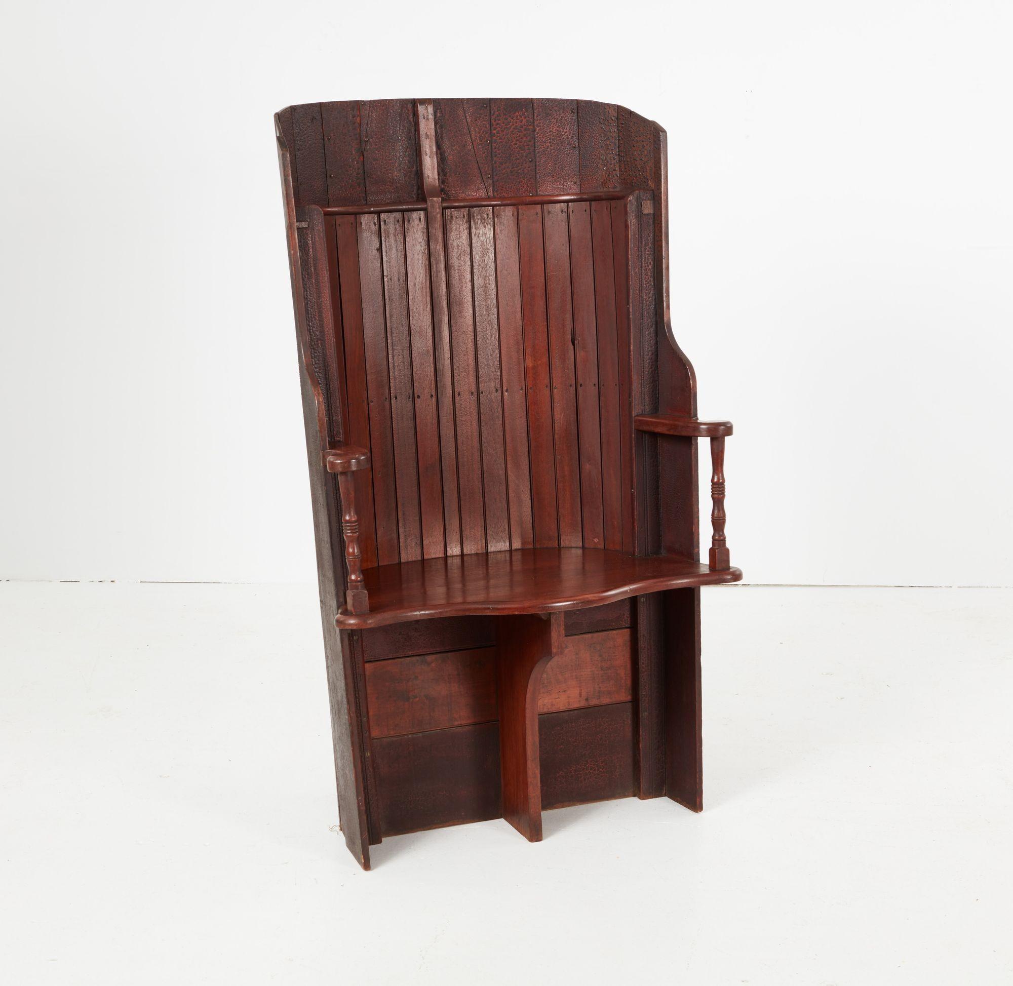A unique armchair with an enveloping raked barrel back made from the ship-lapped hull of a wherry boat, retaining its historic scumble surface. Featuring an inner band of polished lap, outswept arms on turned supports, and a shaped seat with central