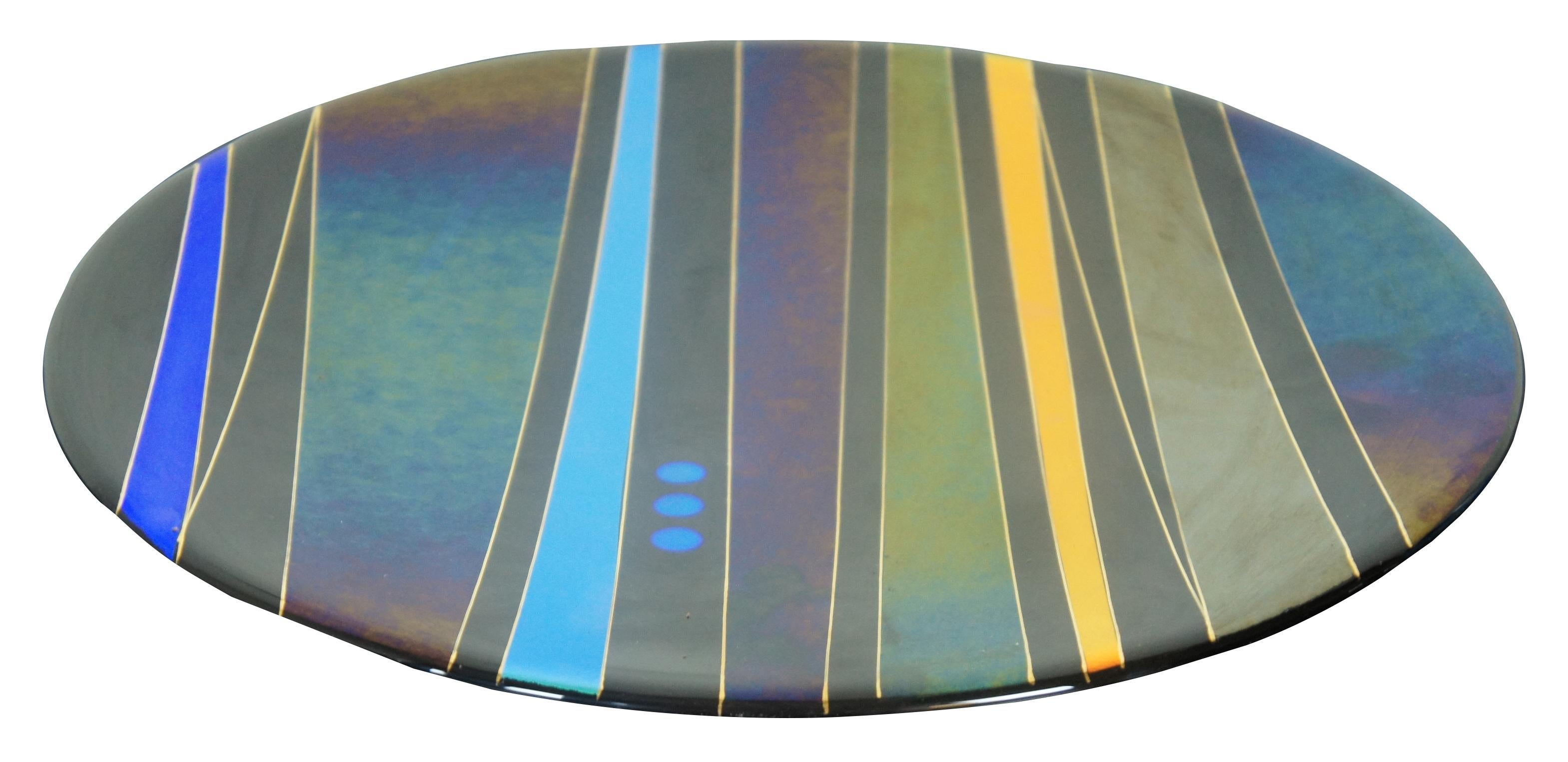 Beautiful Modernist abstract geometric studio art glass plate or charger featuring striped of bold, iridescent colors and gold trim. Made by Jim & Sharon Barrett of Barrett Glass Studios in Memphis, Tennessee.