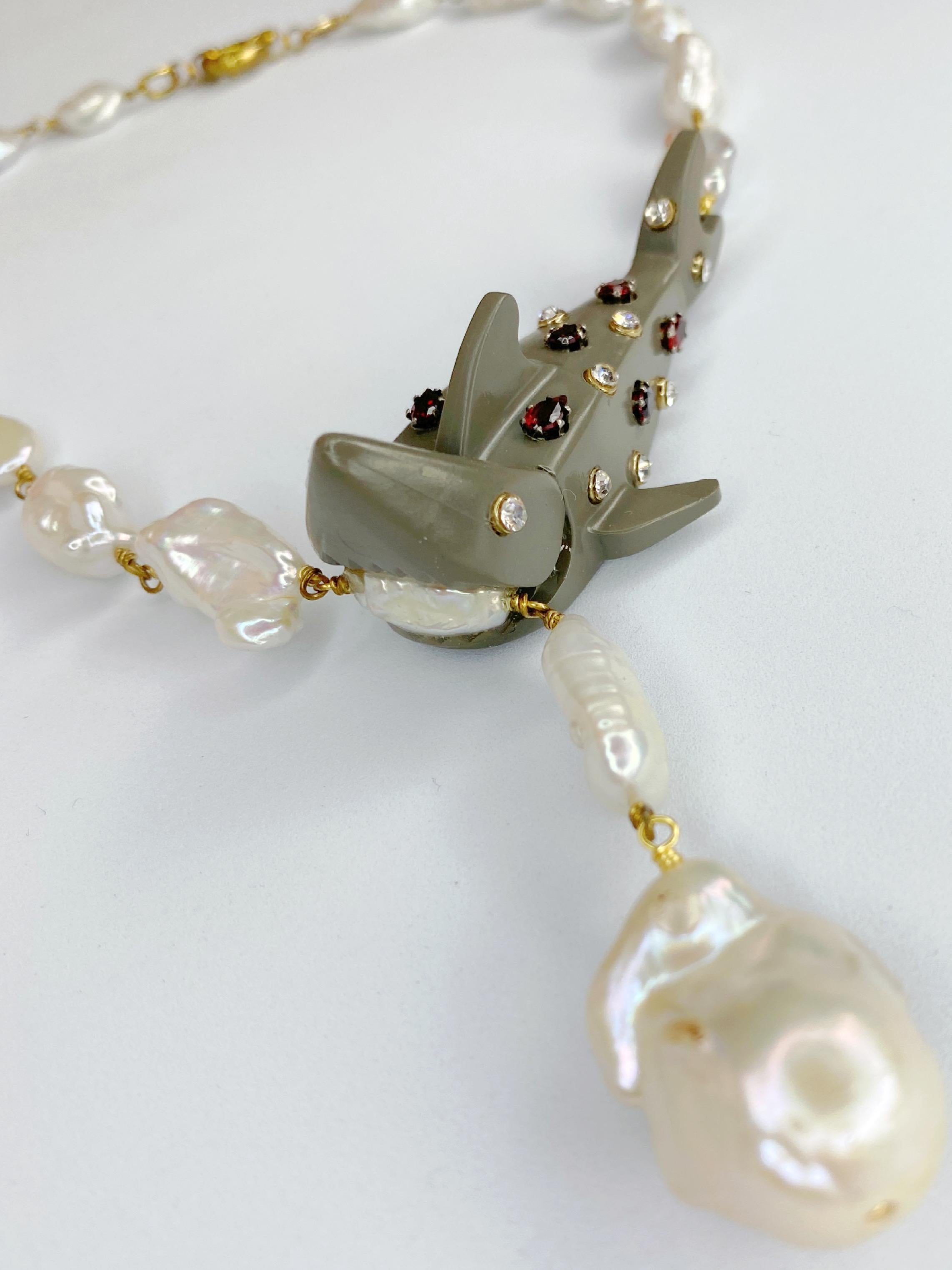 This original one of a kind necklace by Sebastian Jaramillo features barroque pearls and a LEGO shark set with Swarovski crystals and pear cut Garnets. This piece is a sure conversation starter.