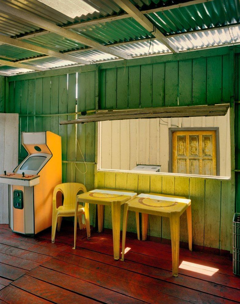 The bright colours of a cafe in a poor district of Salvador in Brazil.
–
The Spaces in Between series developed out of visits to Naples in Italy and Havana in Cuba, two cities whose past glories are suffused with a faded grandeur.  Cawston’s search