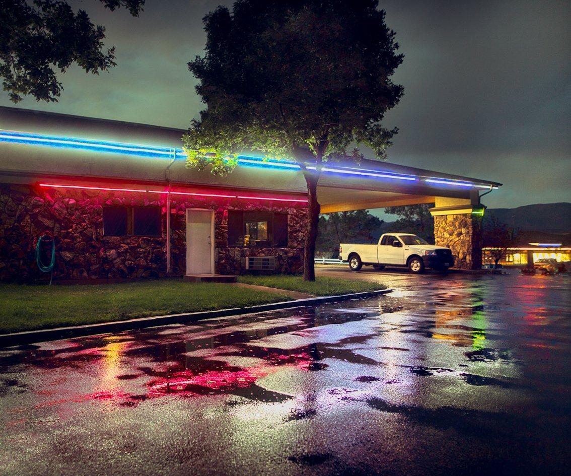 The ubiquitous American motel, neon lit and rain soaked.
–
Cawston’s eye for colour, structure and the beauty of the mundane finds a world-in-waiting as he journeys across the American West.
“The greatest part of a road trip is not the arriving but