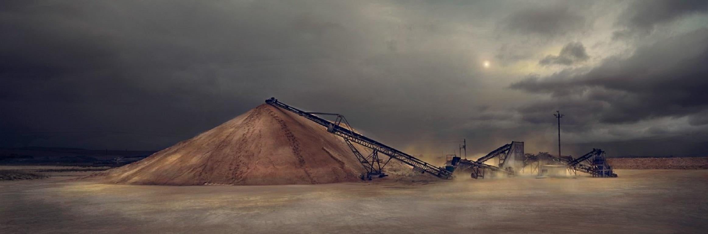 A sand storm blows across a gravel pit in South Africa.
–
Cawston’s Concrete Jungle is not a vision of the ultramodern, of orderly skyscrapers with comfortable interiors.  It is rather of a Blade Runneresque postmodern world where the process of