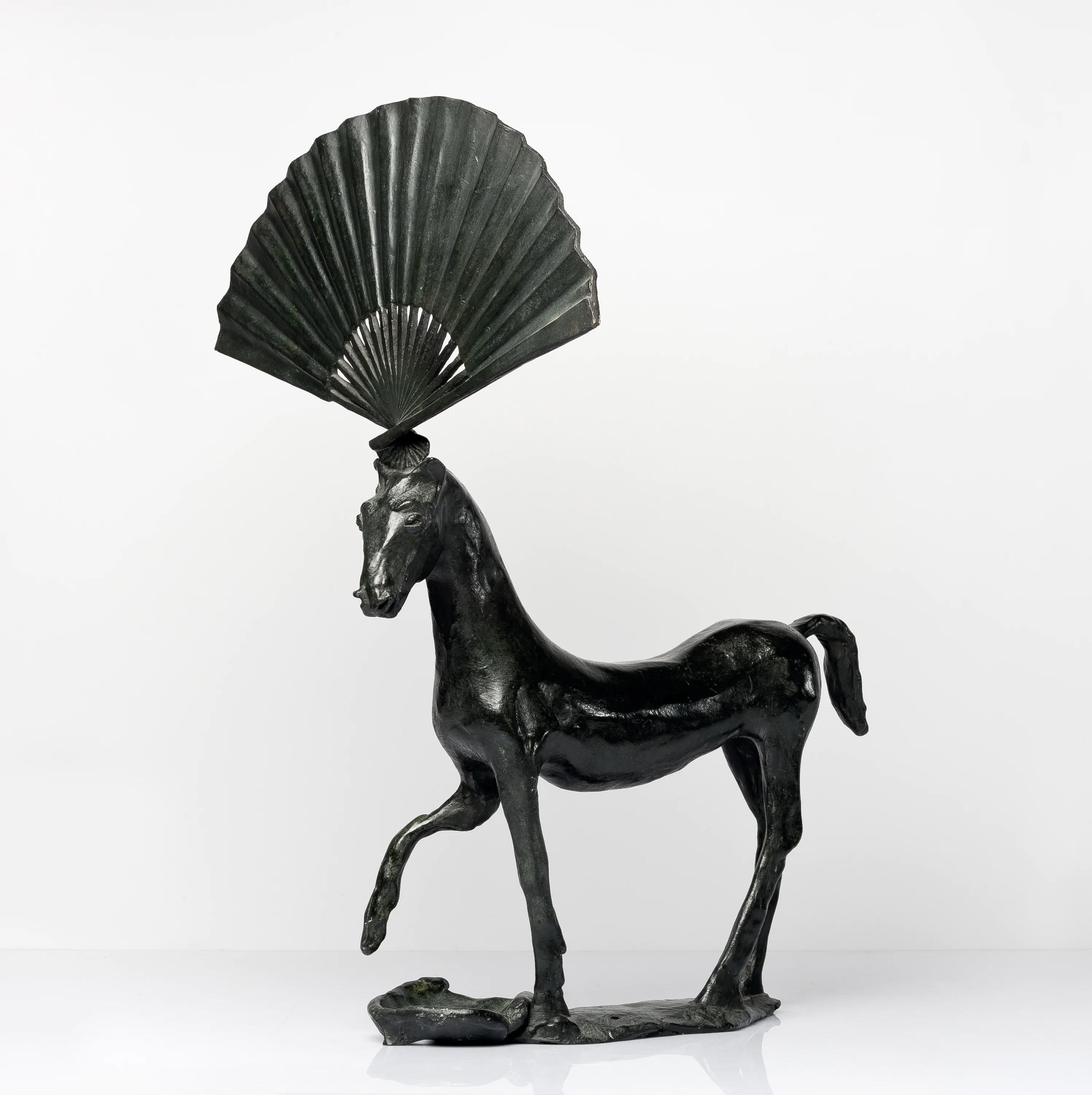 Horse With Fan

By Barry Flanagan

Barry Flanagan (1941–2009) was a British sculptor best known for his dynamic bronze hares, which often appear in playful, human-like poses. His work blends whimsy with technical mastery, and he played a key role in