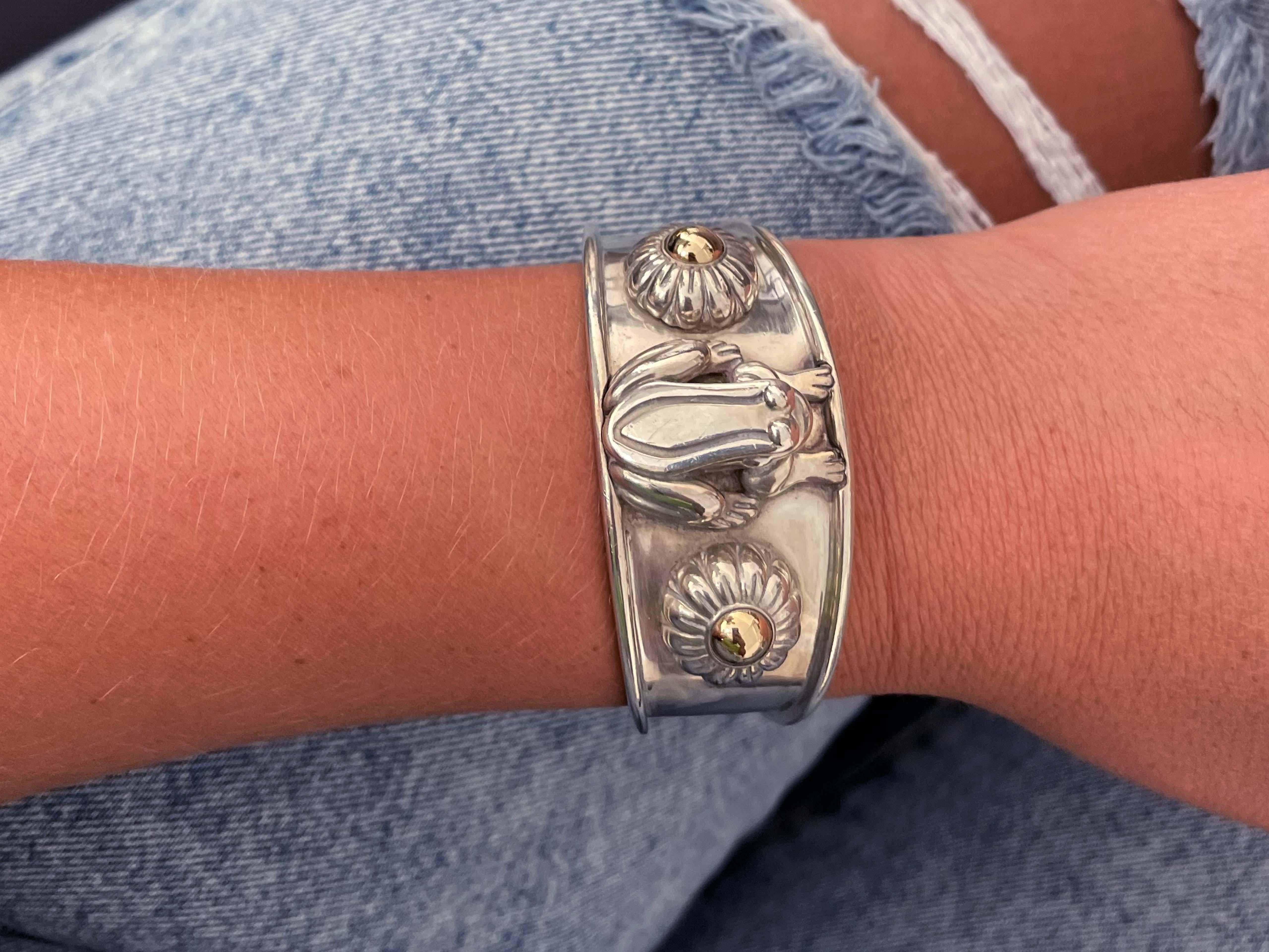Bracelet manchette en cordon Barry Kieselstein en argent sterling et or jaune 14k. Le bracelet présente une grenouille en 3D entre deux fleurs en 3D avec des pétales en or jaune 14k. Poinçonné 