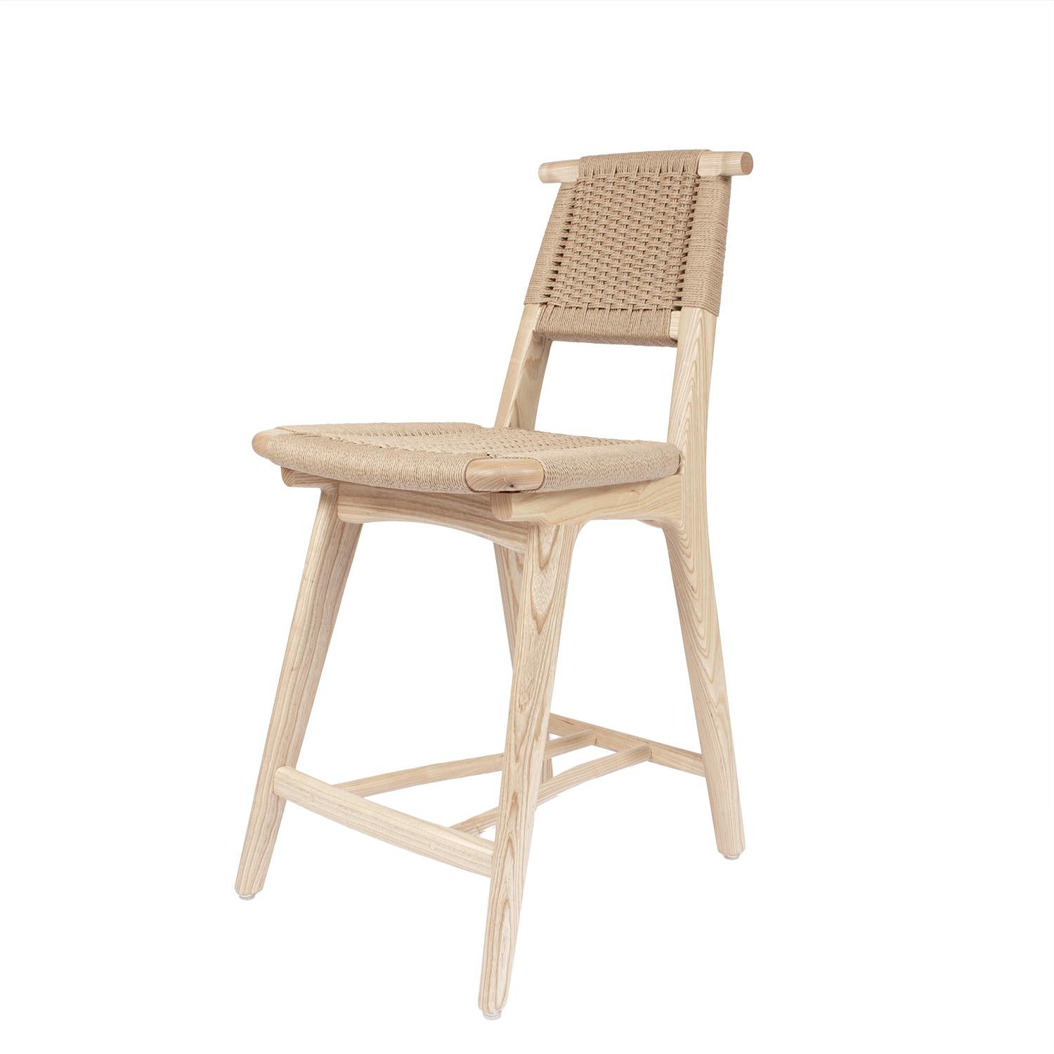 Hardwood Rian Bullhorn Barstool with a woven Danish Cord seat deck and back. Crafted with precision and a keen eye for detail, the Rian Bullhorn Barstool embodies the essence of modern aesthetic with its sleek lines and functional design. Ideal for