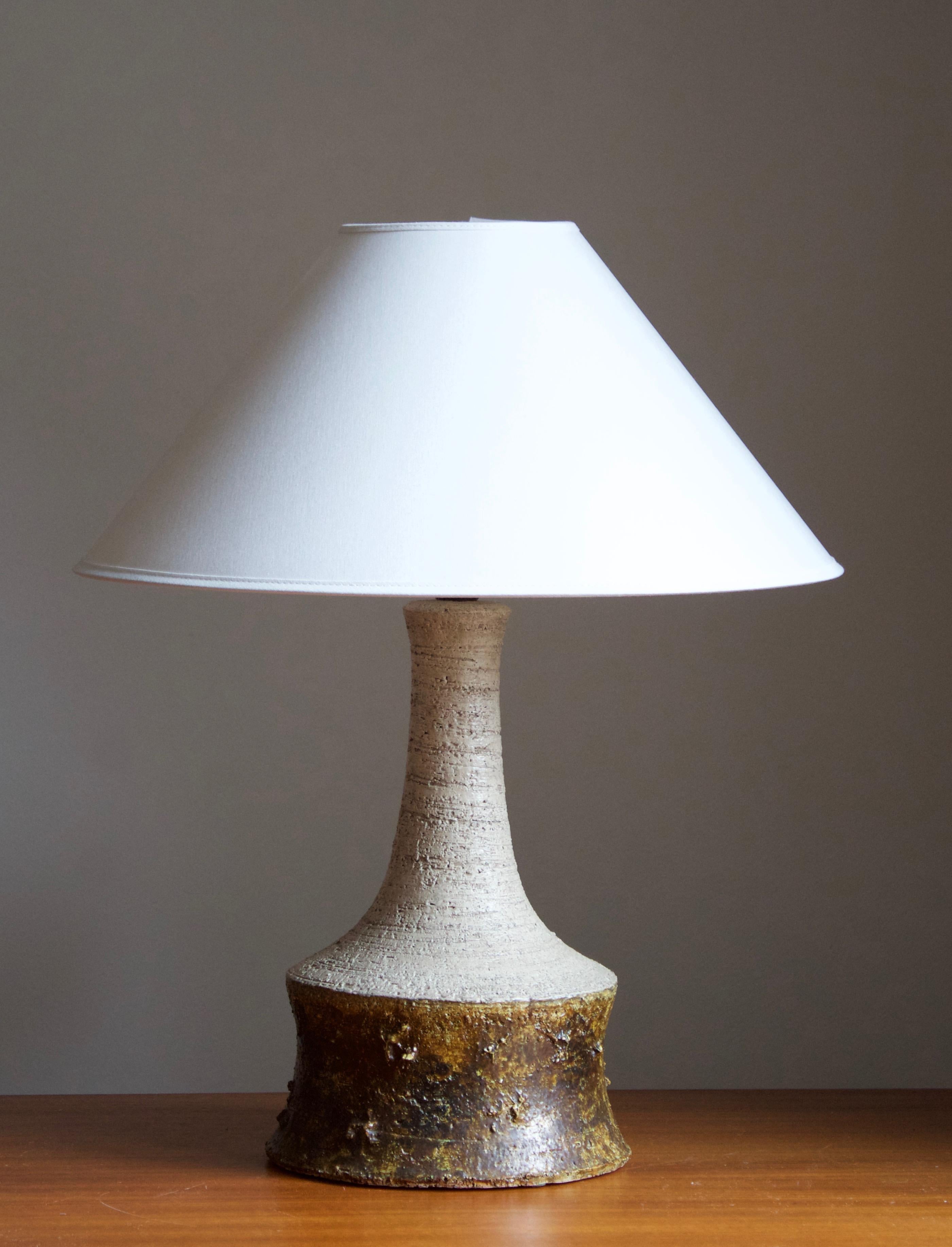 A table lamp produced and design by Bartholdy, Denmark, 1960s. Stamped.

Lampshade is attached for reference and are not included in the purchase. Measured without lampshade. Height includes socket.

Glaze features brown-grey colors.

Other