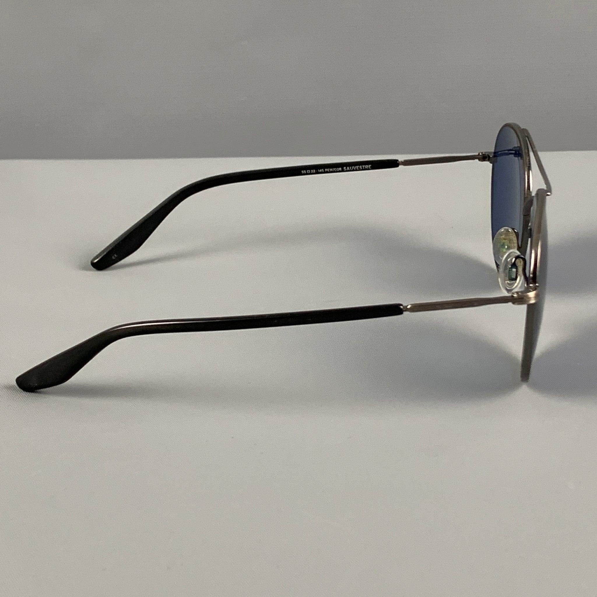 BARTON PERREIRA sunglasses comes in a silver tone metal featuring blue tinted lenses.
 Very Good
 Pre-Owned Condition. 
 

 Marked:  55-22-145  
 

 Measurements: 
  Length: 14 cm. Height: 5 cm.
  
  
  
 Sui Generis Reference: 121114
 Category: