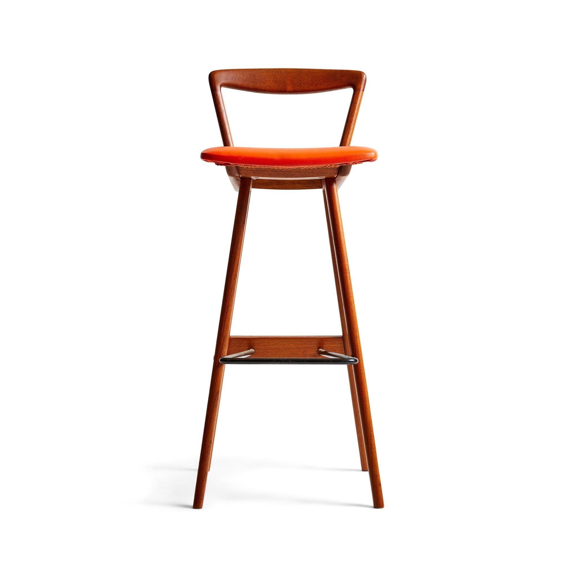A barstool crafted from teak, featuring a cushioned vinyl seat and a tubular metal stretcher serving as a footrest.