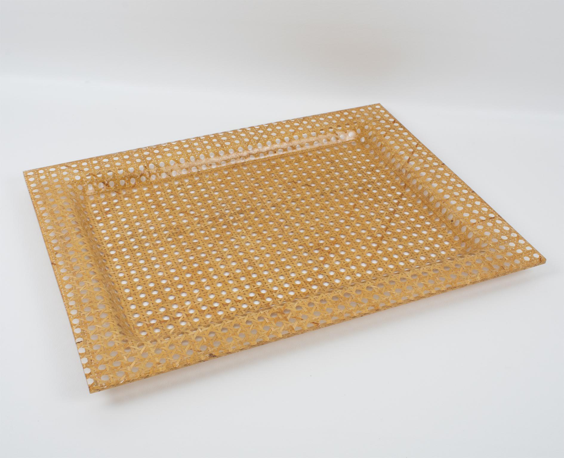 This stunning modernist barware serving tray or platter was crafted in Italy in the 1970s. The rectangular shape has raised edges built with two layers of clear Lucite or acrylic and between a layer of rattan, wicker, or cane-work and geometric
