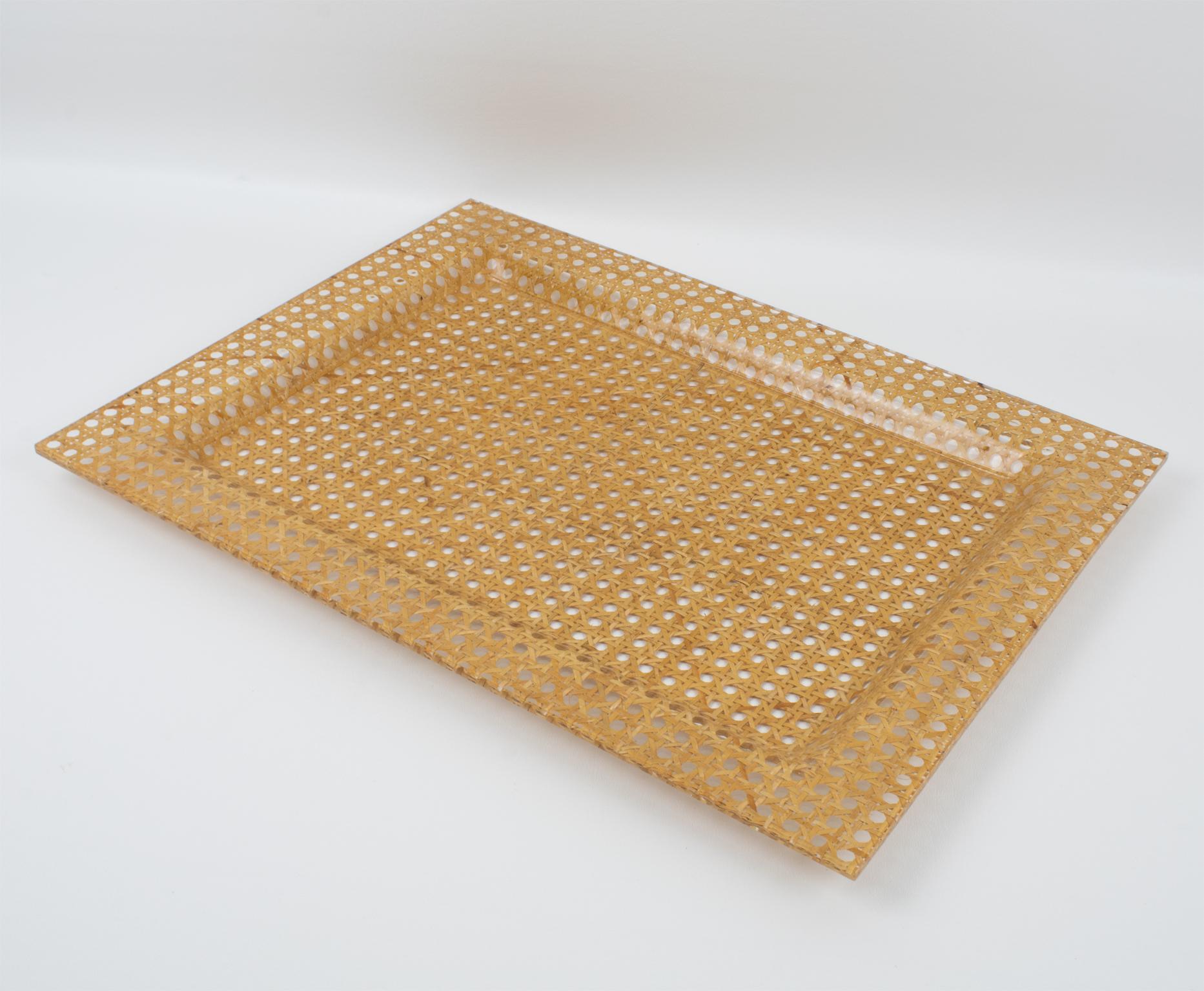 This stunning modernist barware serving tray or platter was crafted in Italy circa 1970. The exquisite rectangular shape features raised edges constructed from two layers of clear Lucite or acrylic, a layer of rattan, wicker, or cane work, and