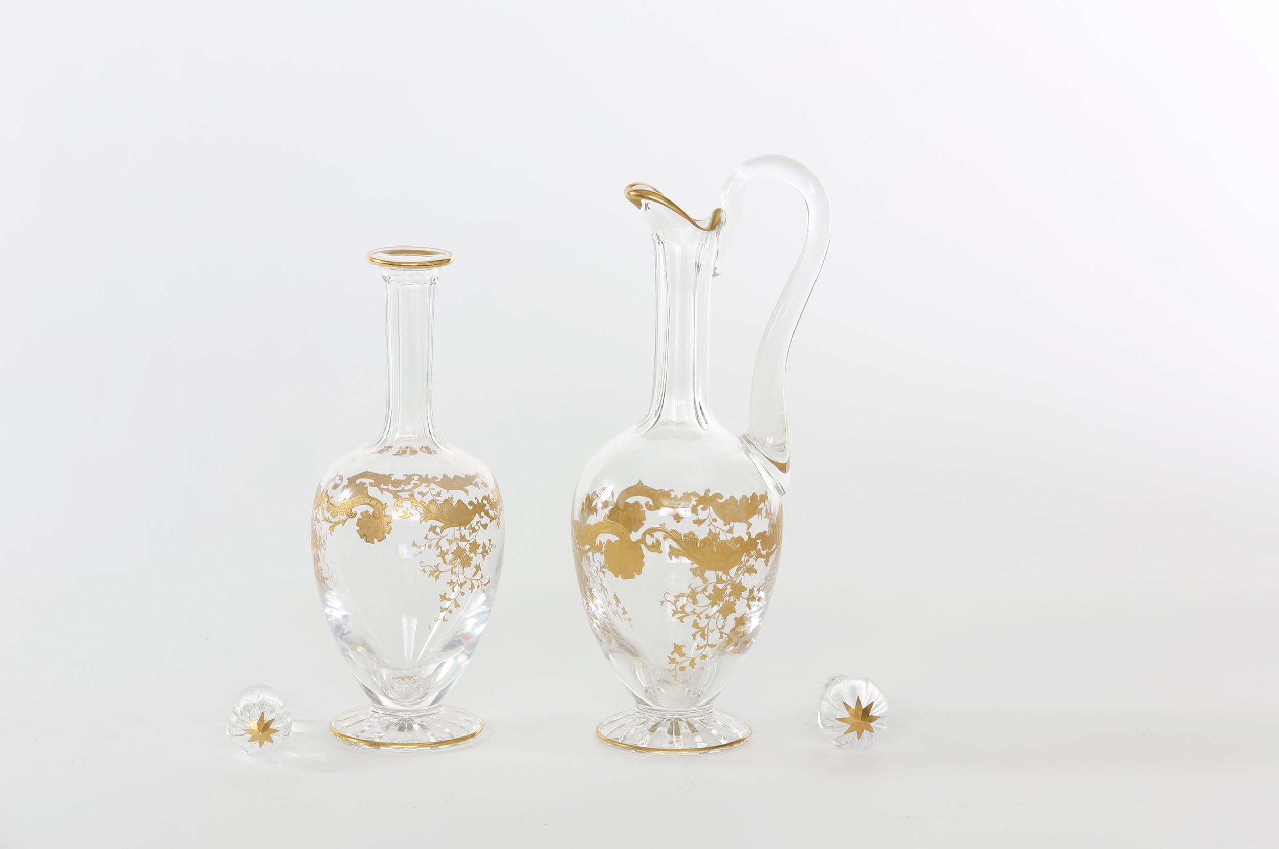 Mid-20th century pair Saint Louis crystal / gold design details tableware / barware jugs decanters. Each one is in great condition. Maker's mark stamped undersigned. The one with the handle stands about 15 inches tall x 5 inches diameter and 13
