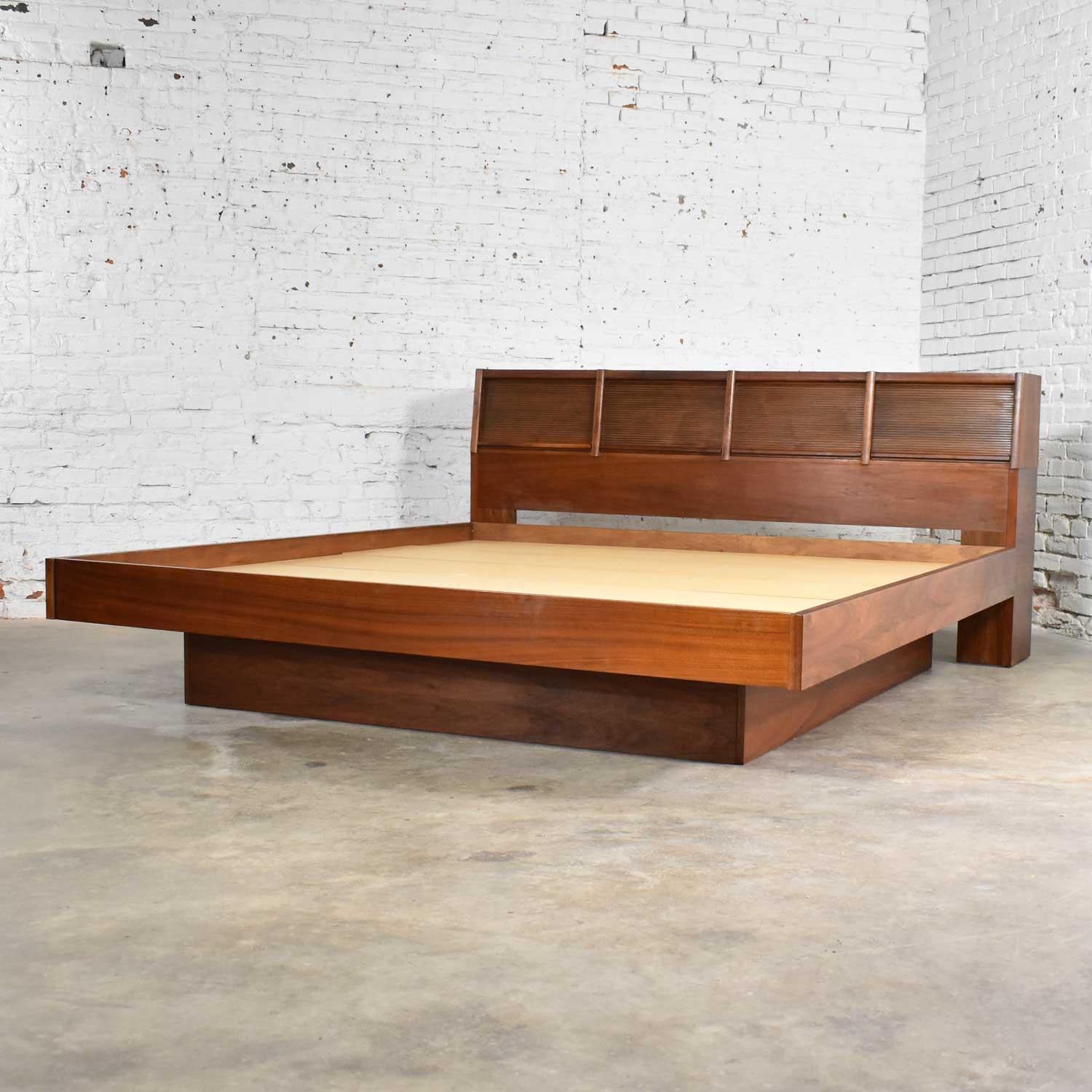 Handsome king size Scandinavian Modern style walnut platform bed with bookcase headboard and tambour doors plus wall mount shelf bedside tables, by Barzilay Furniture Manufacturing Company. It is in fabulous vintage condition with no outstanding