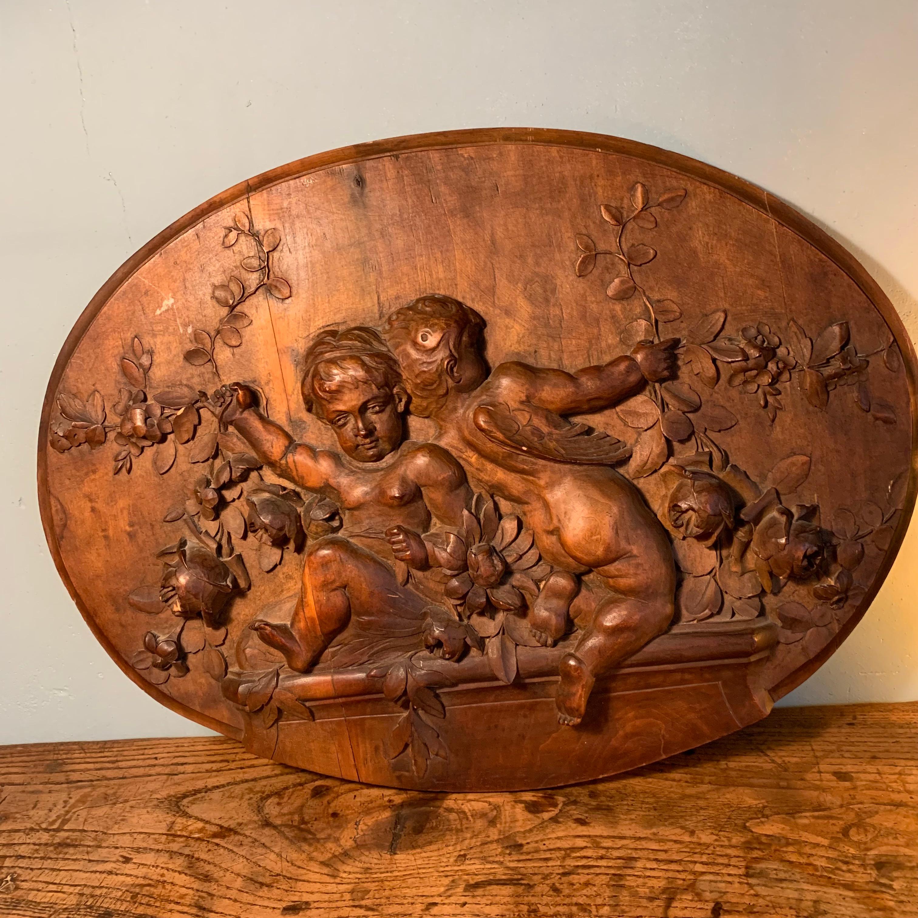 Bas relief en médaillon en bois sculpté à décor de putti du 19ème siècle. Charmant et intemporel. Décor sculpté d'une grande finesse.