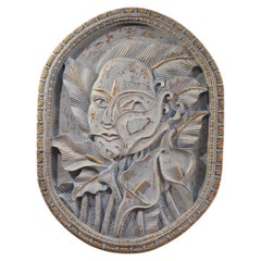 Bas-relief sculpture, stylized face with flowers, 20th century