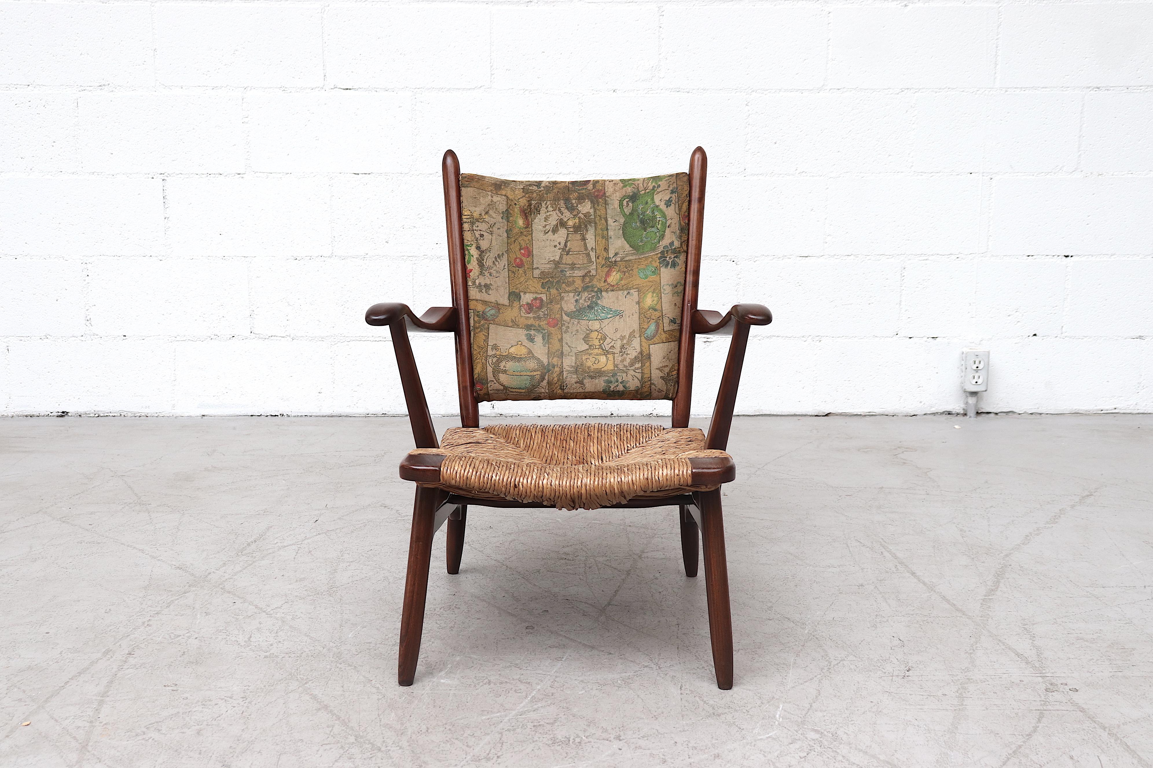 Petite Bas Van Pelt style low back lounge chair with rattan seat and curved arms. Lightly refinished with rattan weaved seat rest and curved back. In original condition with normal wear consistent with age and use. A complimentary high back chair