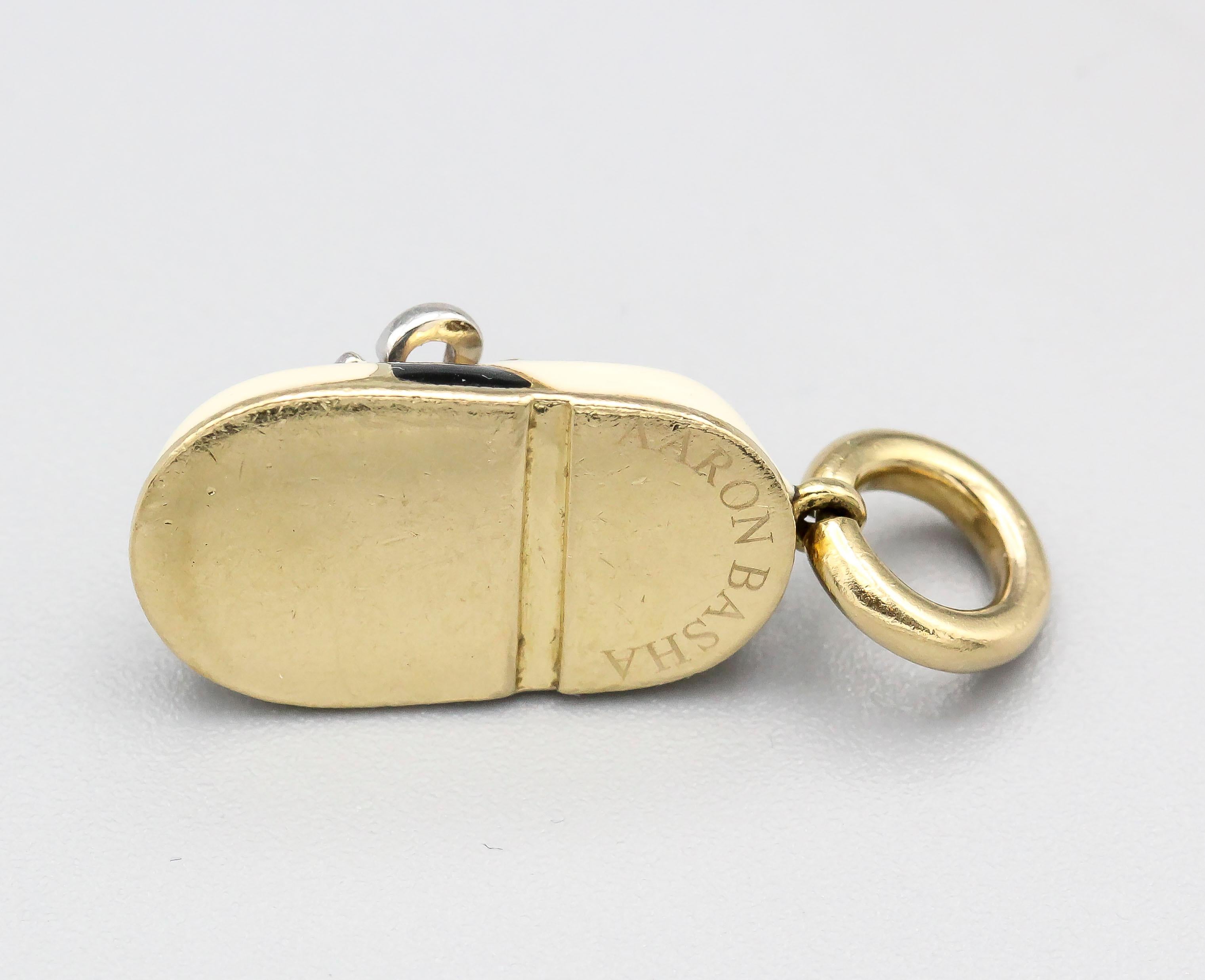 Whimsical diamond, blue enamel and 18K yellow gold baby boy shoe charm by Aaron Basha. Featuring black and ivory colored enamel with one single high grade round brilliant cut diamond over a gold setting.

Hallmarks: Aaron Basha, maker's mark, 750,